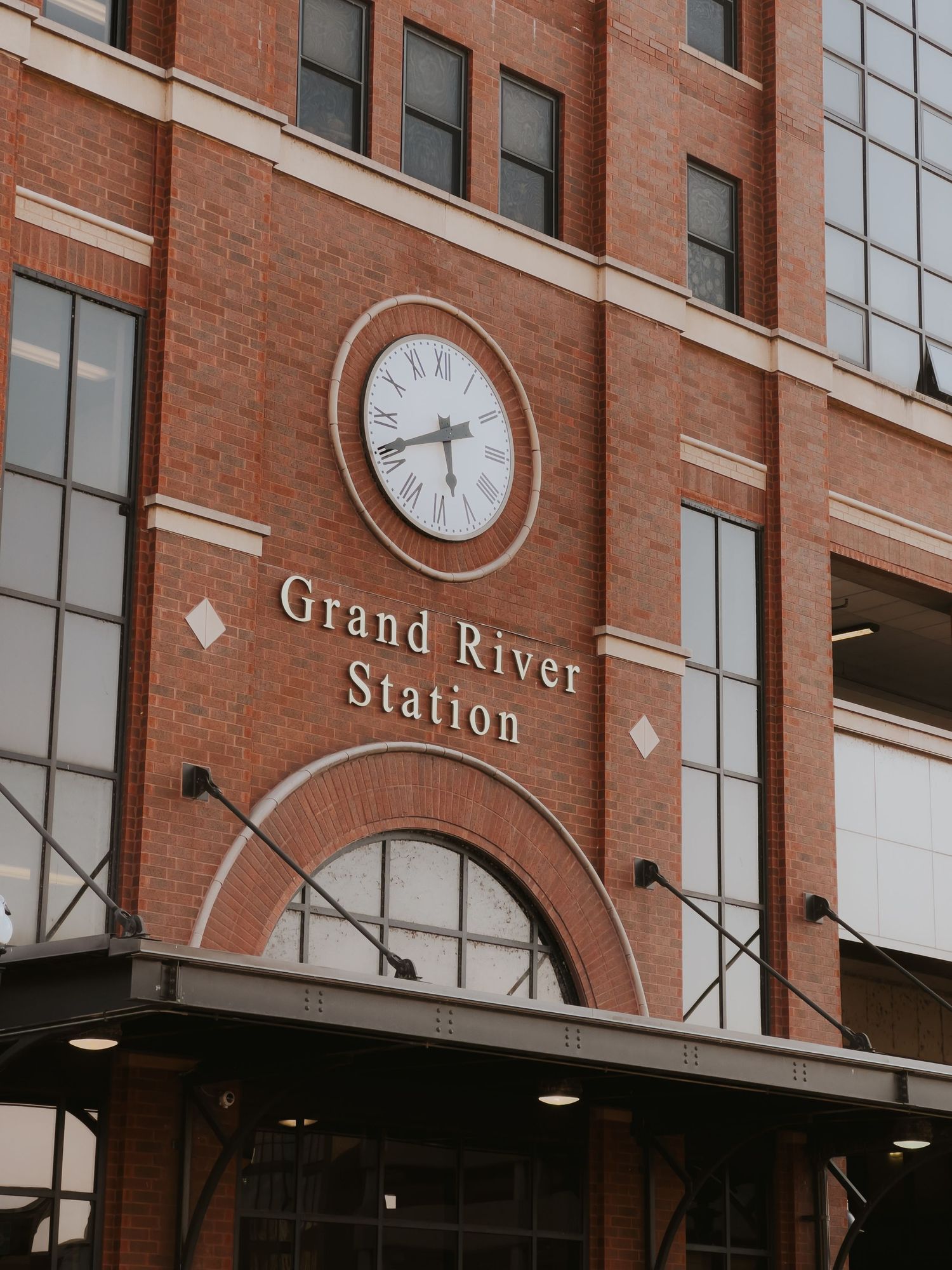 Exterior view of Grand River Station building with red brick facade and wall-mounted clocks.