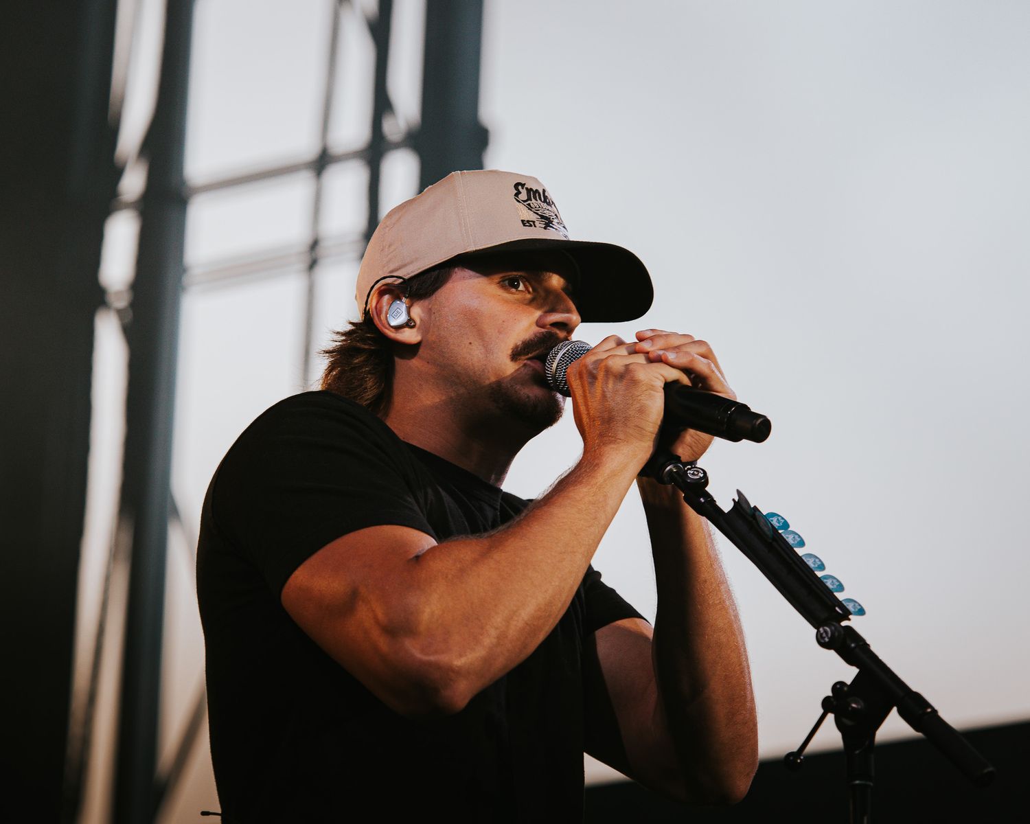 Silhouetted performer singing into microphone during dramatic stage performance.