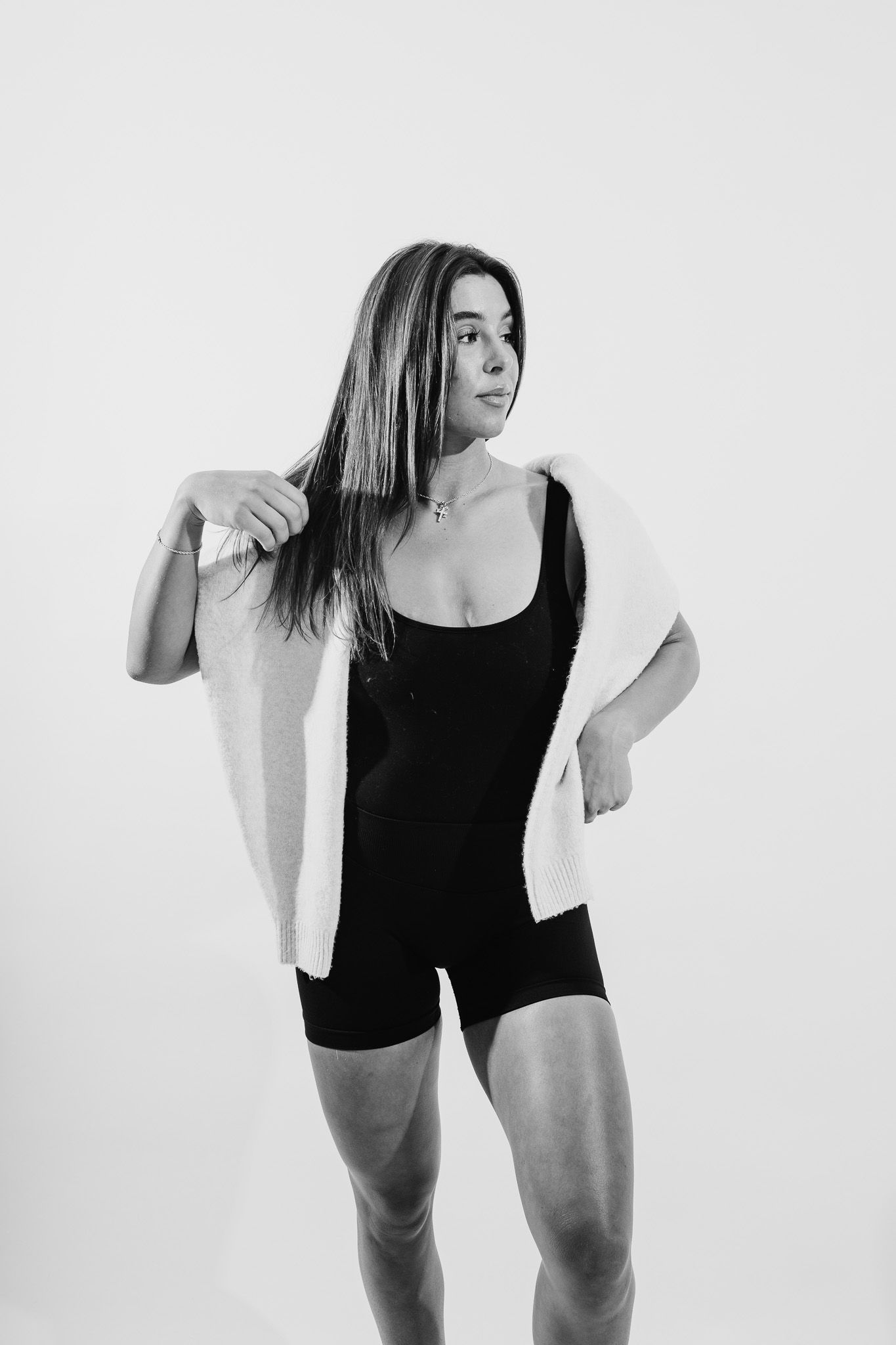 Black and white portrait of a person in athletic wear posing against a plain background.