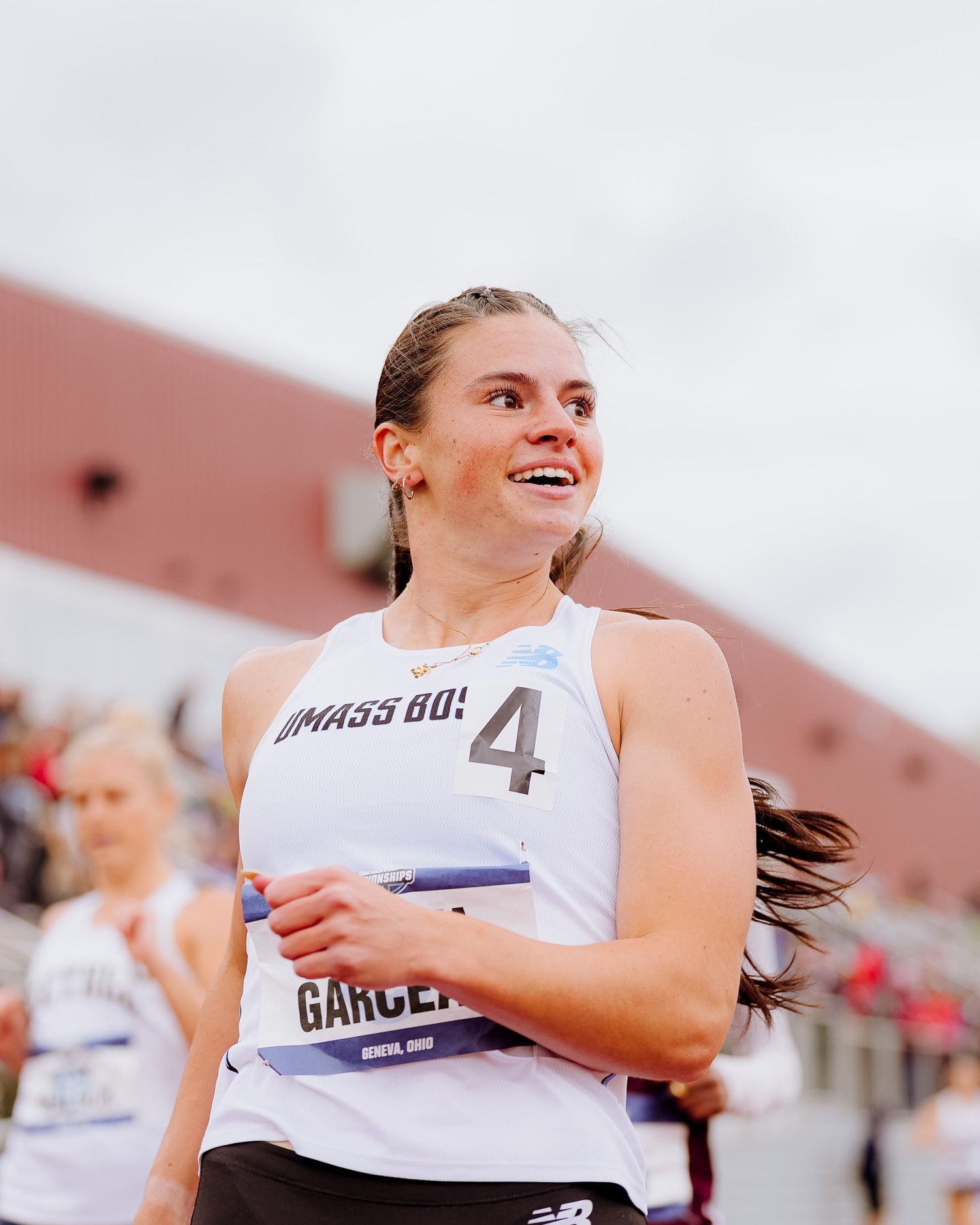 Athletes in white jerseys celebrate and smile during a competitive sporting event.