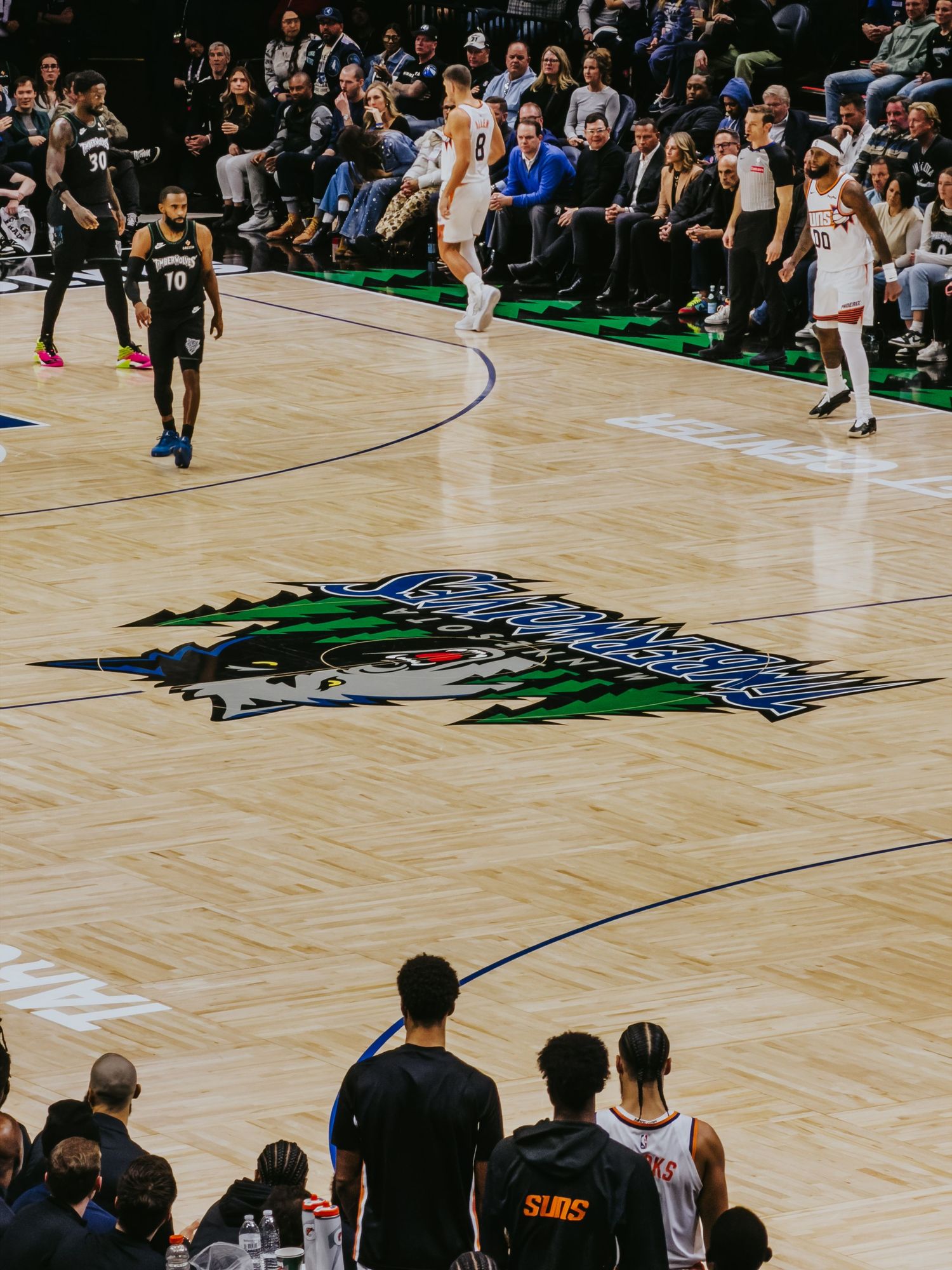 NBA players and officials gather around a fallen player on the basketball court during a game.