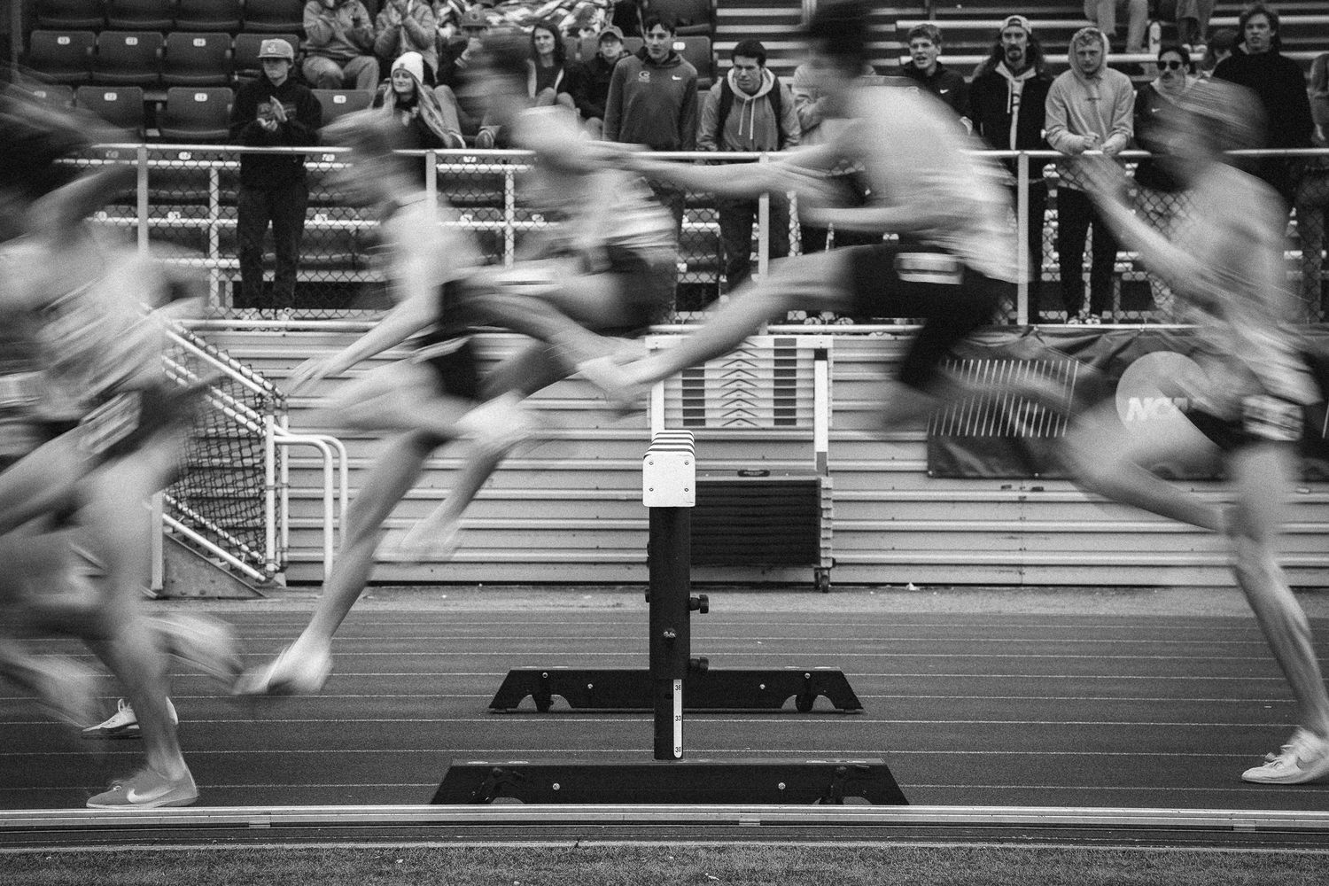 Motion blur of runners' feet in a race competition on a track surface.