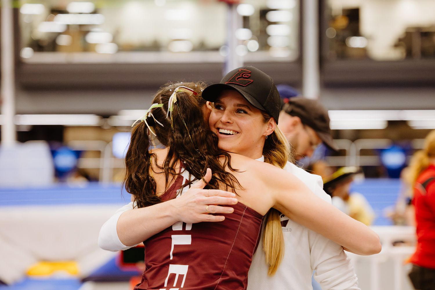 Athletes embrace in celebration after competing in a track and field event.