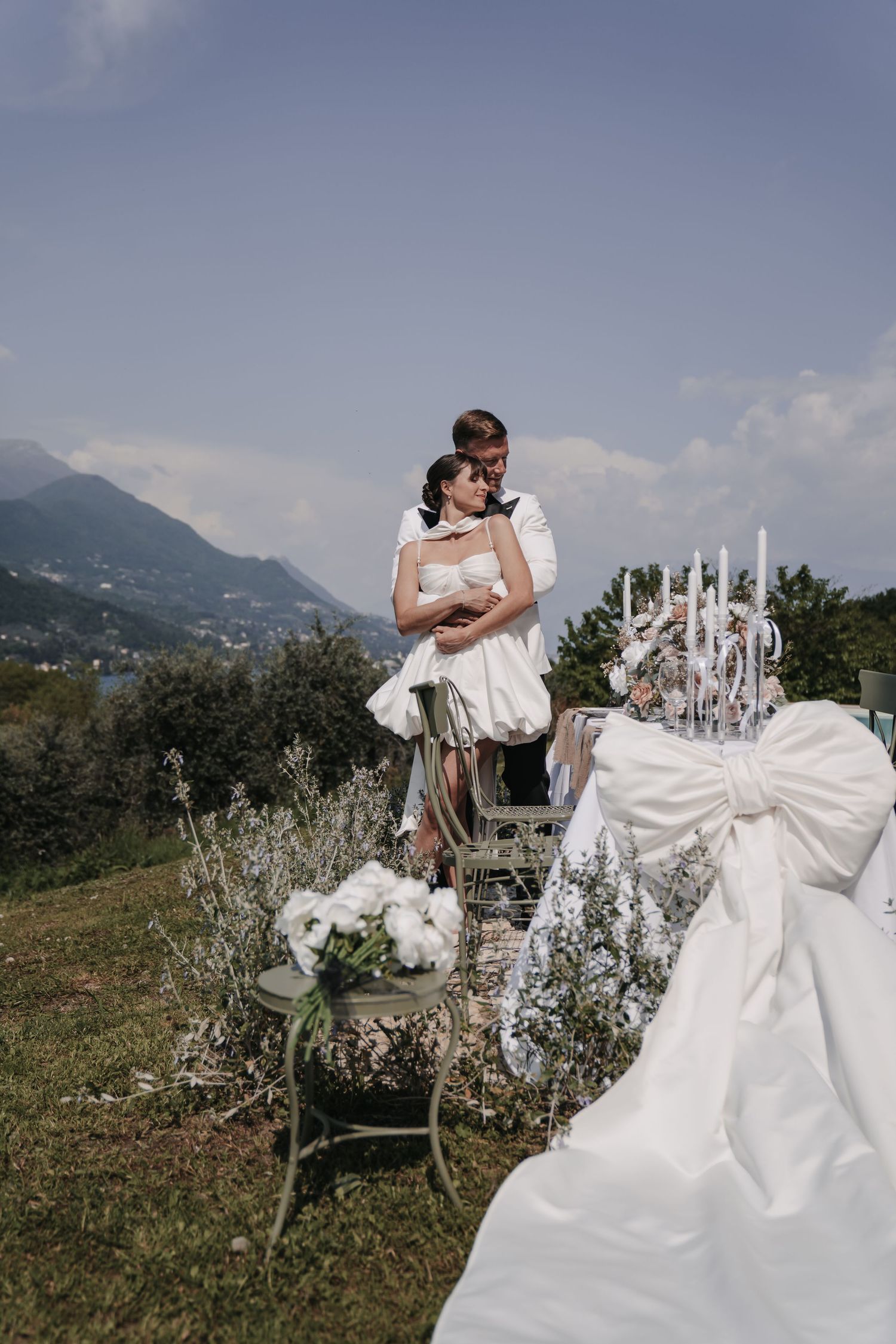 Brautpaar in einer Gartenlaube vor Bergpanorama in Italien