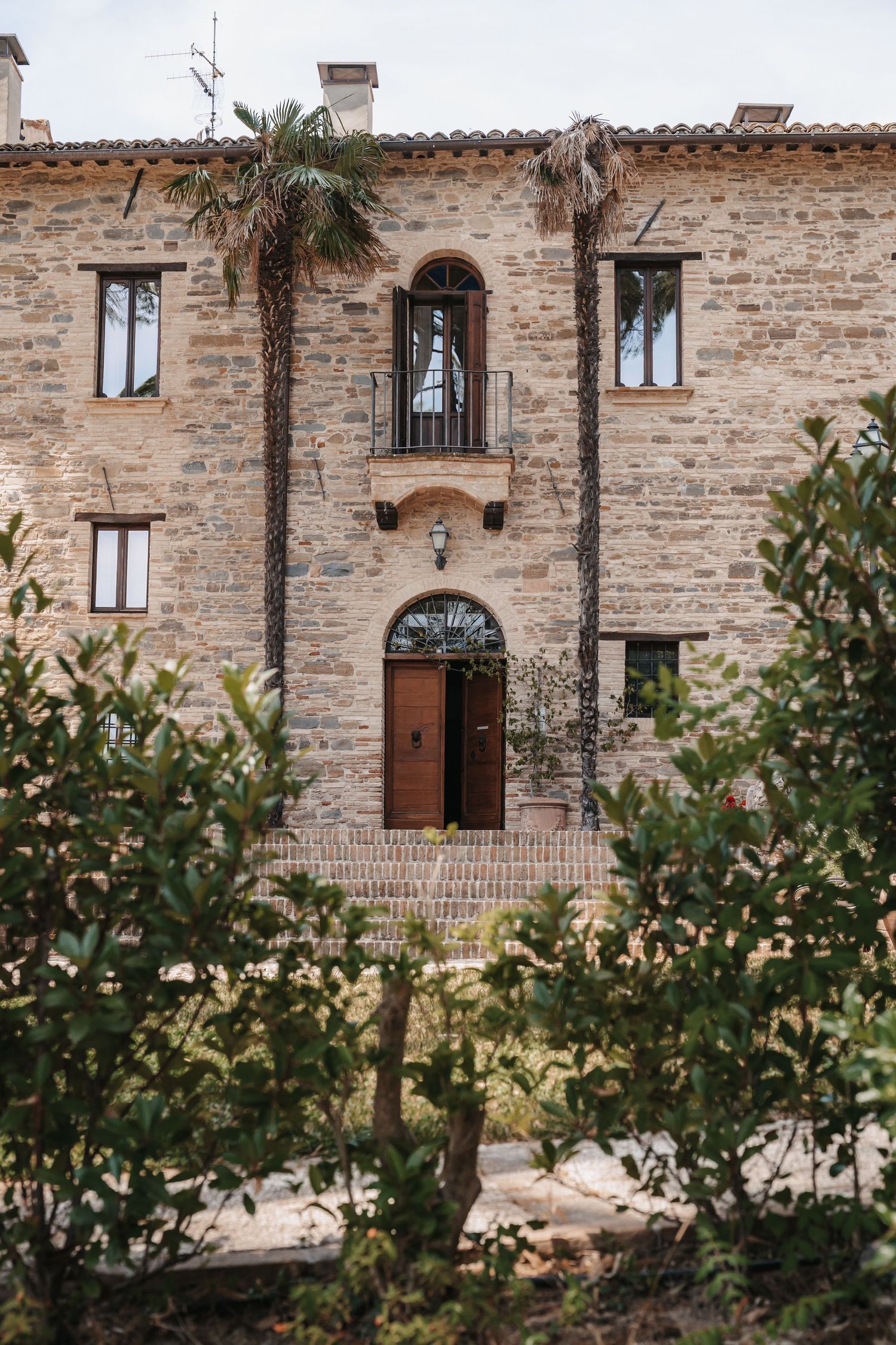 Italienisches Steinhaus mit Fensterläden und Olivenbäumen
