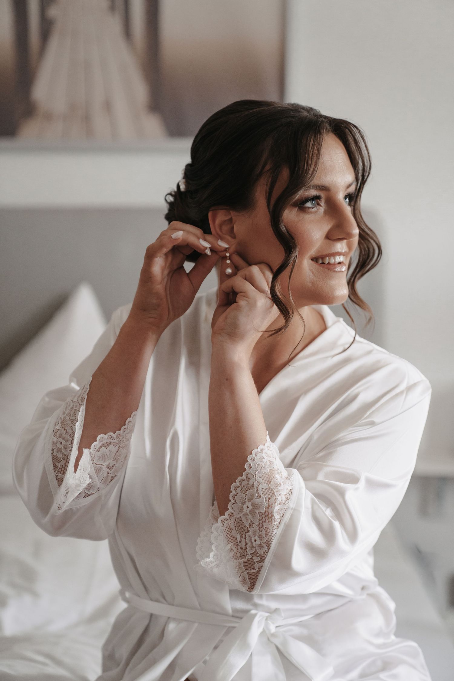 Braut beim Getting Ready, sie legt ihren Ohrring an