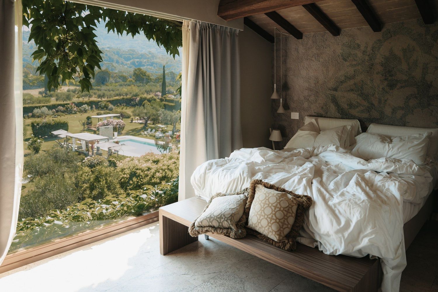 Schlafzimmer mit Fensterblick ins grüne Tal