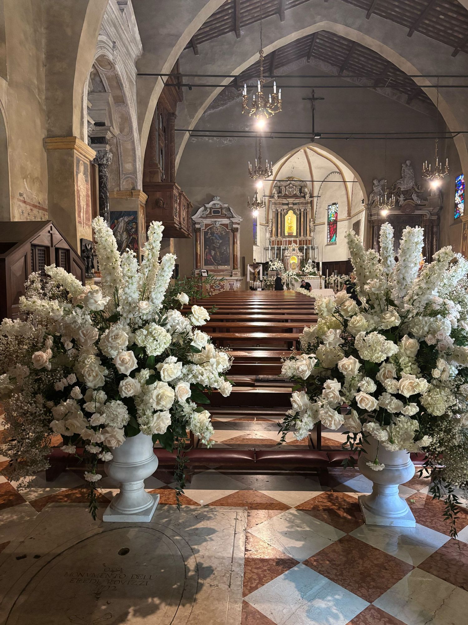 Mit weißen Blumen geschmückte Kirche in Italien vor einer Trauung
