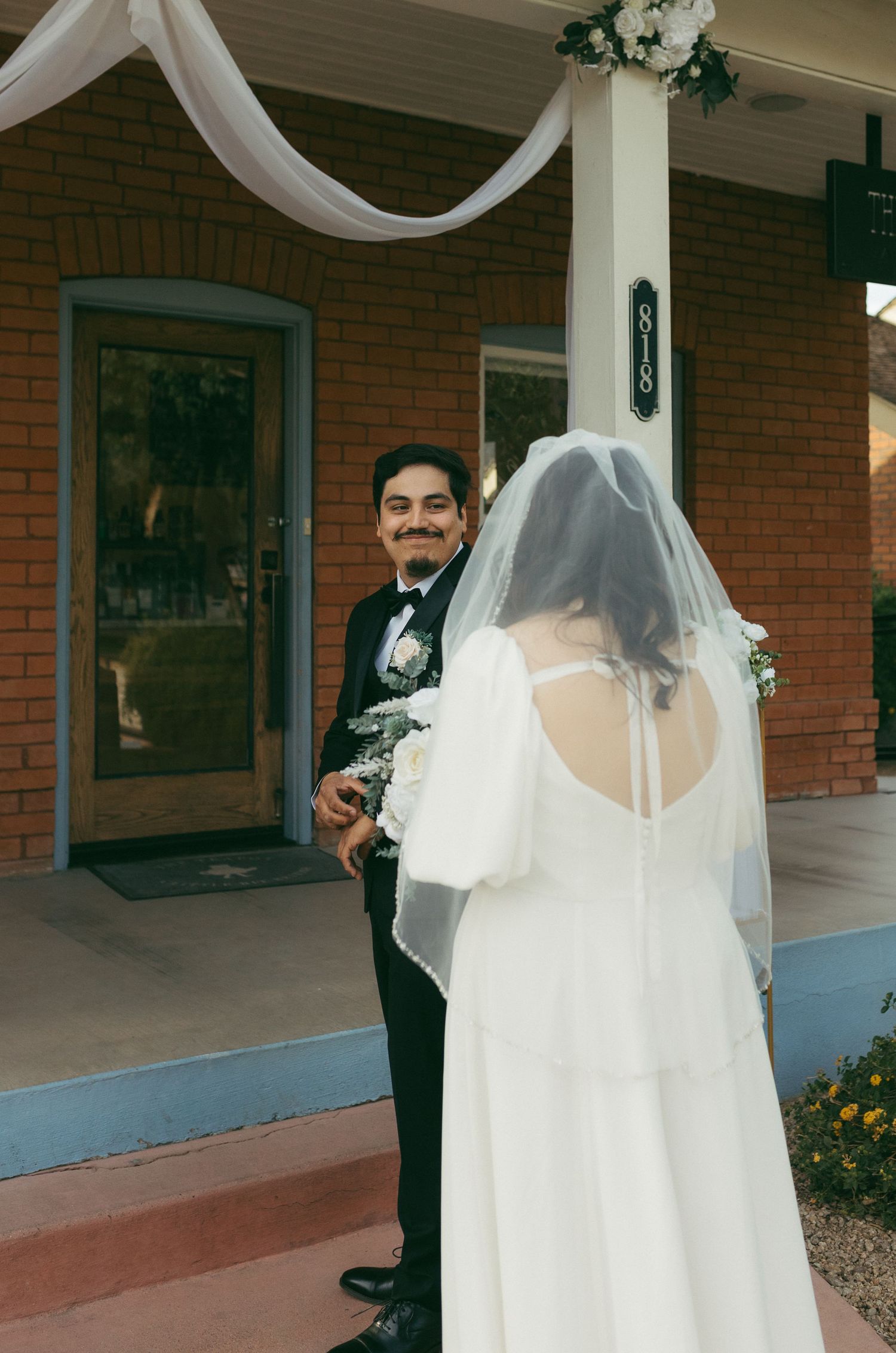 Candid and emotional first look between the bride and groom, captured on film-inspired tones.