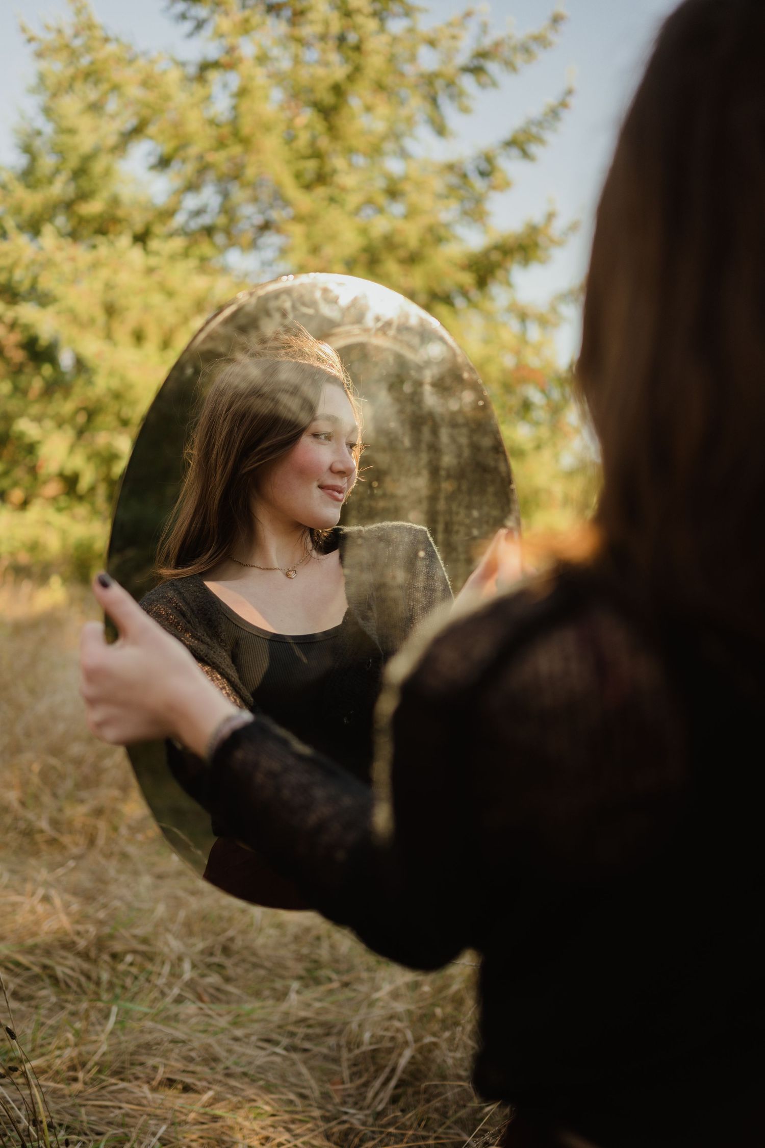 Ethereal mirror portrait in golden afternoon light with autumn foliage.