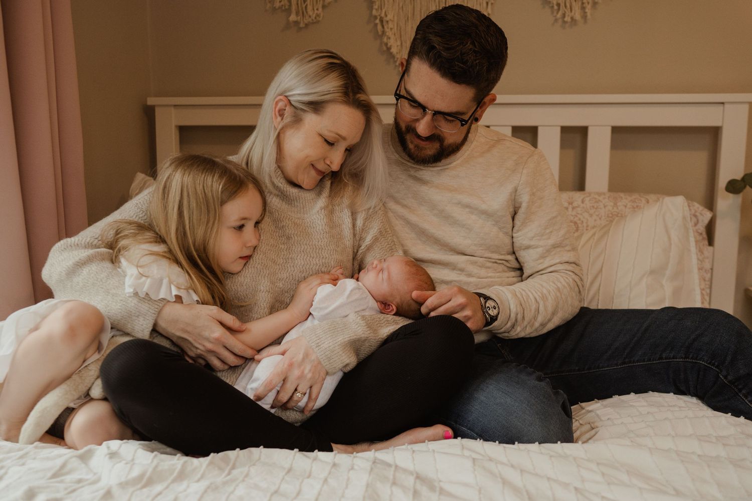 A cozy family gathering on bed sharing quiet moments together.