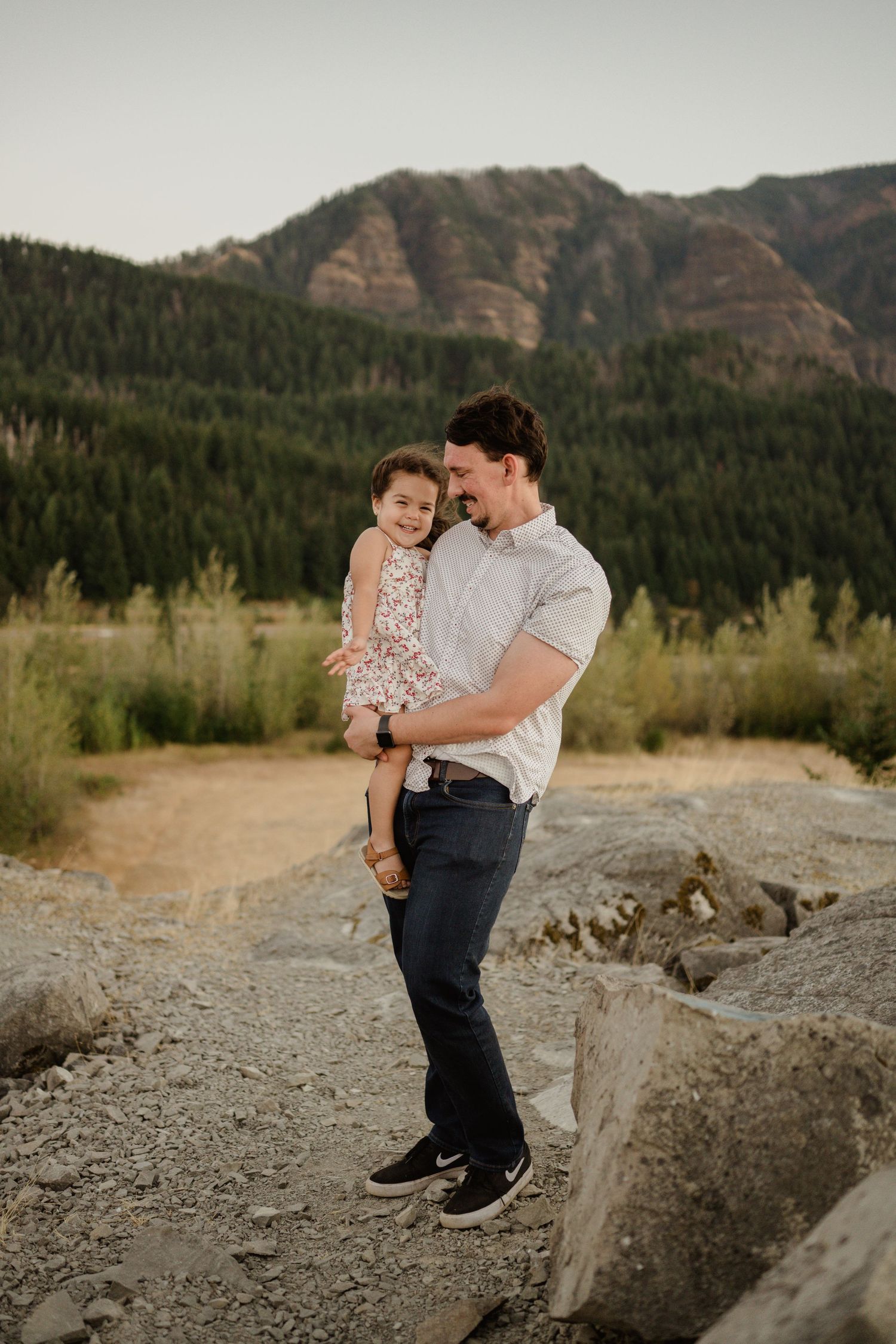 Family enjoying outdoors against mountain backdrop in scenic wilderness setting.