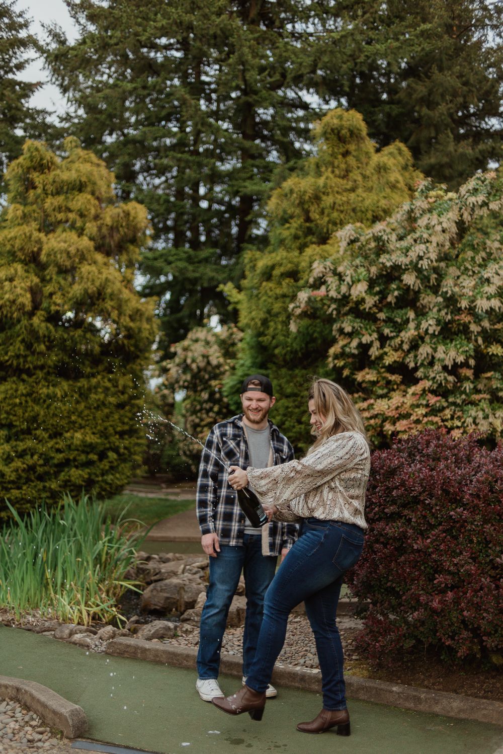 A playful couple enjoying a game of mini golf surrounded by landscaped gardens.