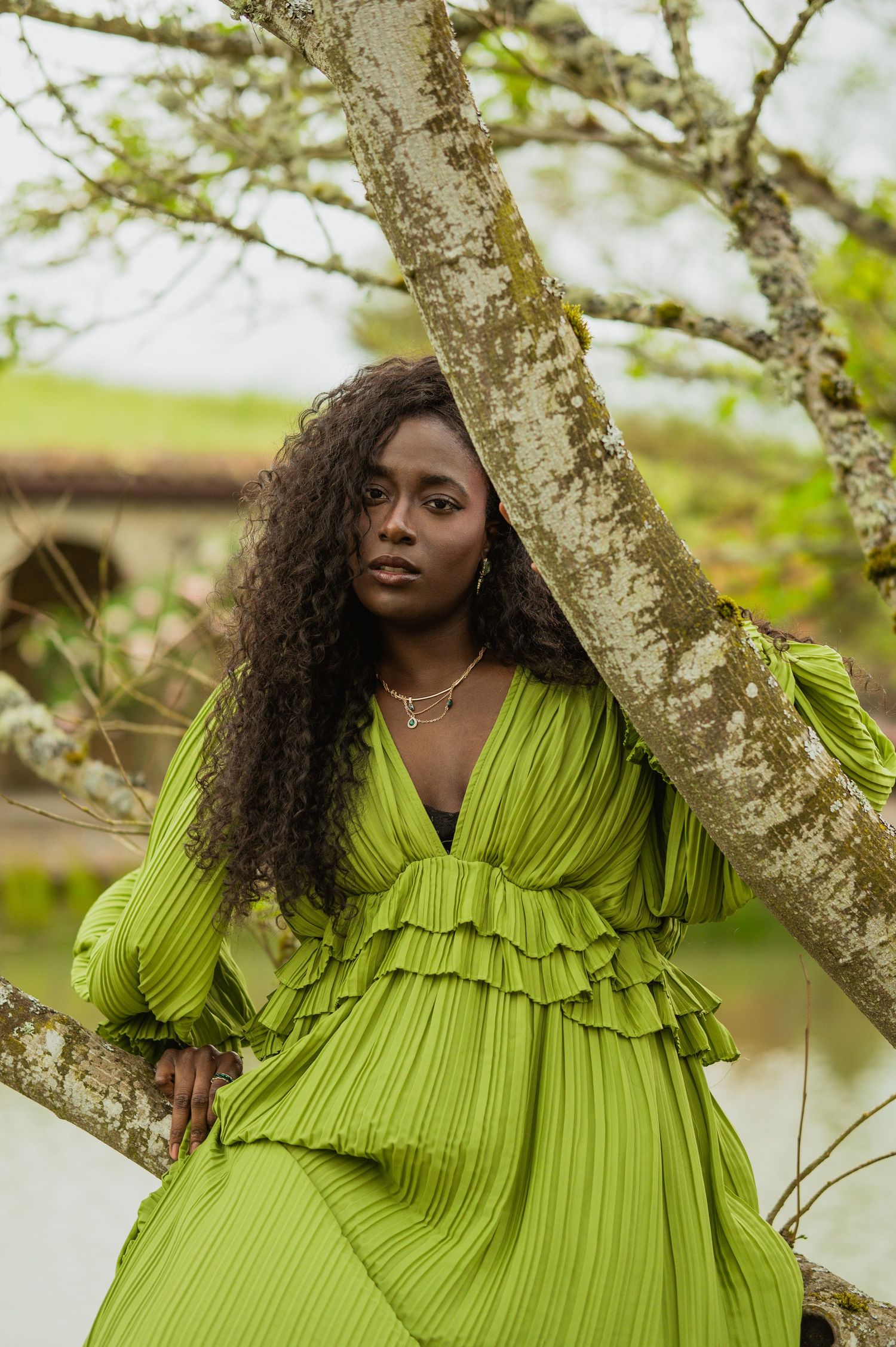 A striking lime green ruffle dress is showcased against a rustic backdrop with birch trees and soft natural light.