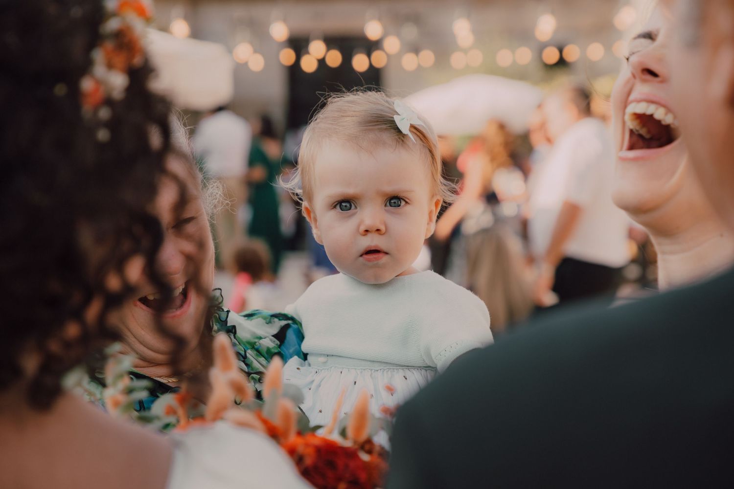 Close-up of young child in formal wear at wedding reception.