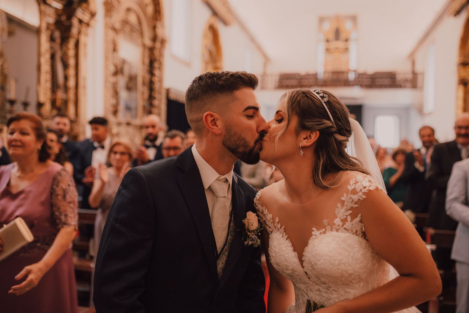Romantic wedding moment in an ornate church interior.