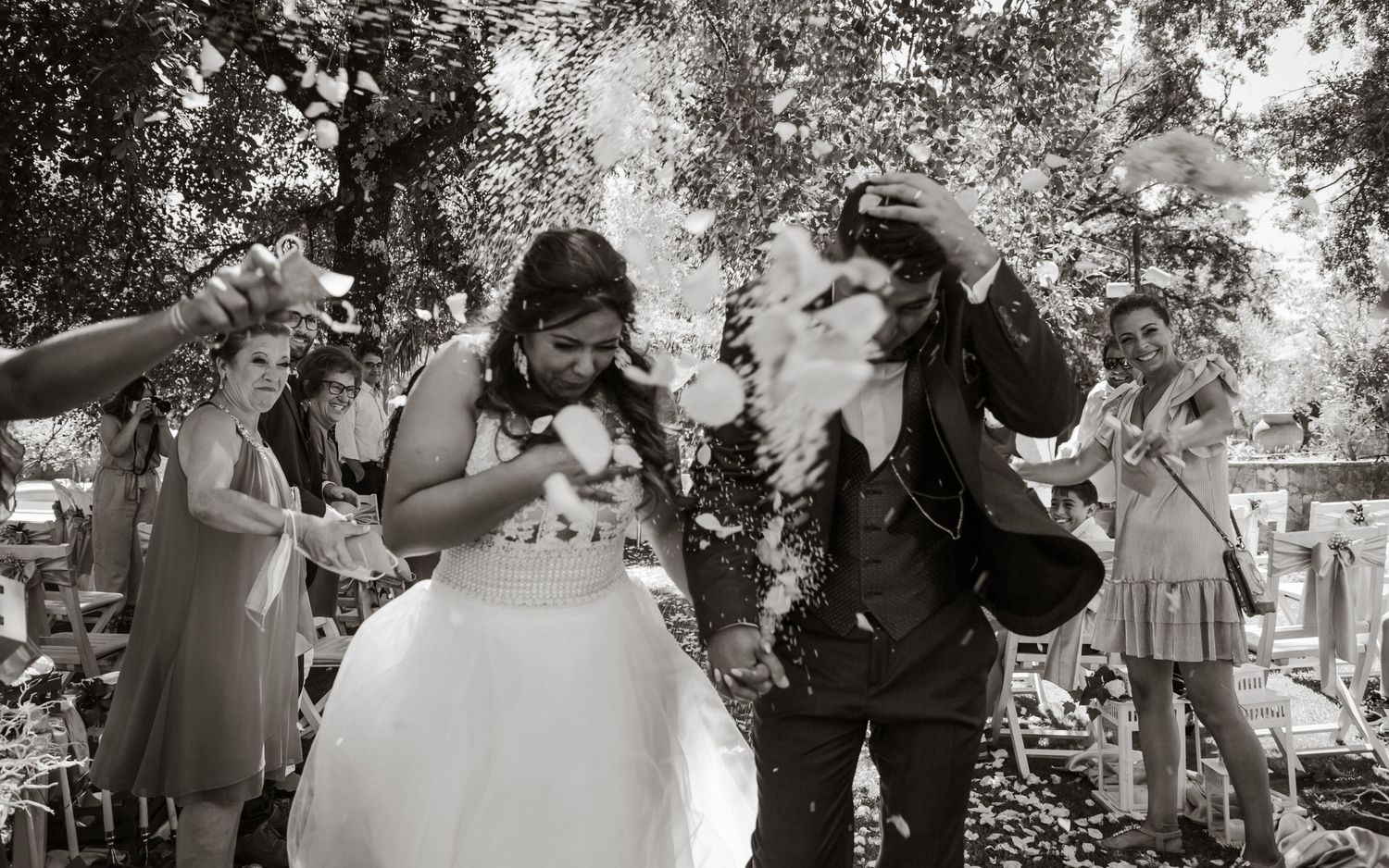Wedding guests celebrate with sparklers during a fun outdoor black and white moment.