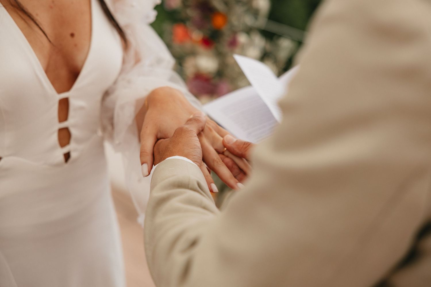 Close-up of wedding rings and hands during ceremony.