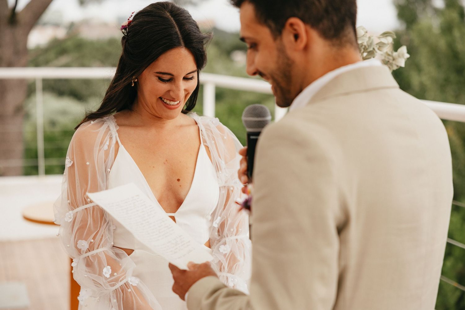 Intimate wedding ceremony moment with microphone and lace details.