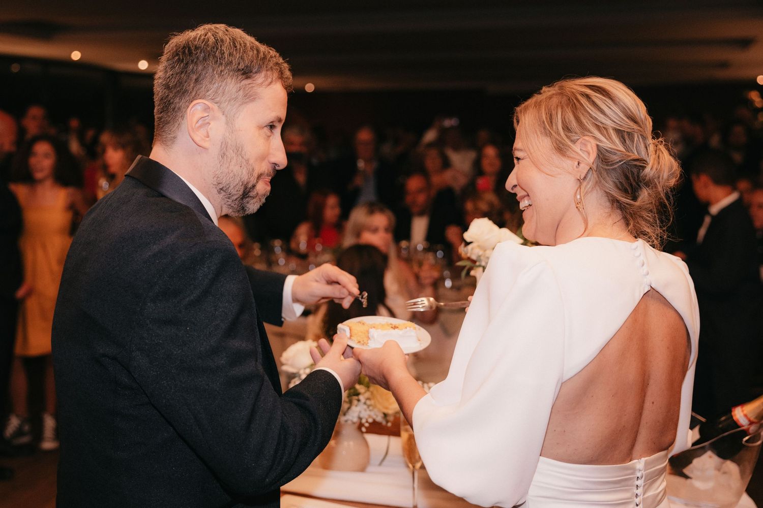A joyful candlelit moment between newlyweds during their wedding reception.