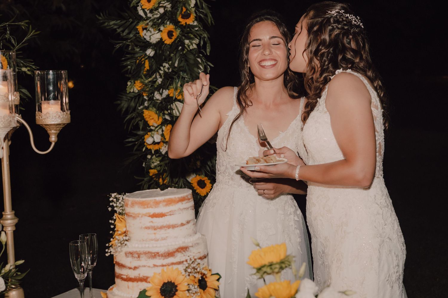 Wedding celebration with sunflower-decorated cake and joyful moments between wedding attendees.