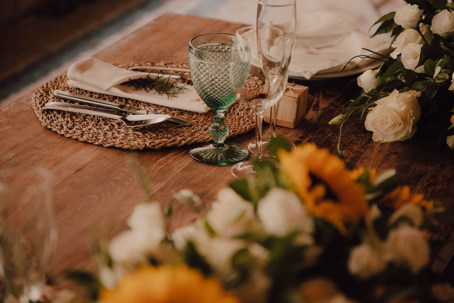 Elegant table setting with crystal glassware and floral centerpieces at wedding reception.