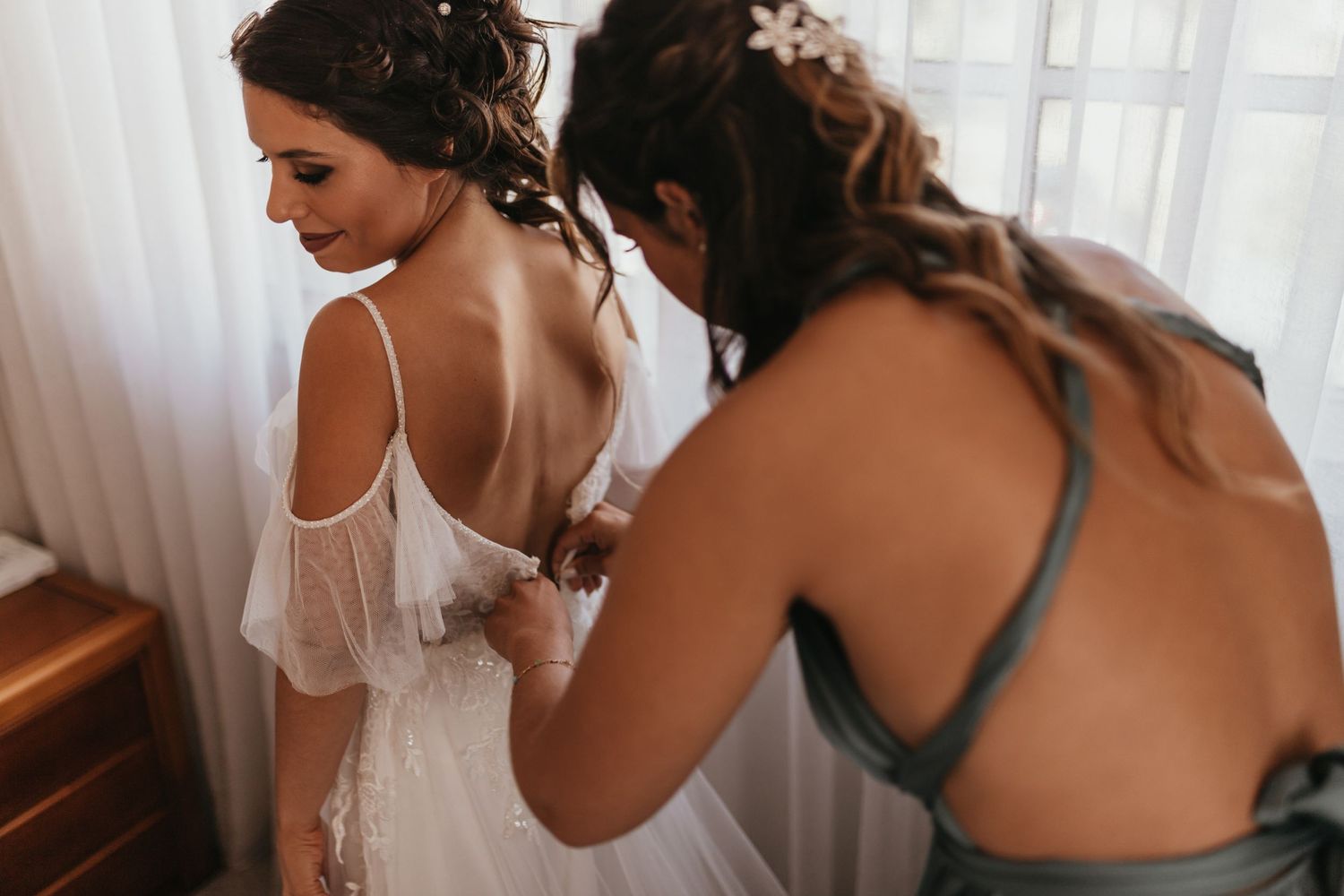 Getting ready scene with wedding dress preparation.