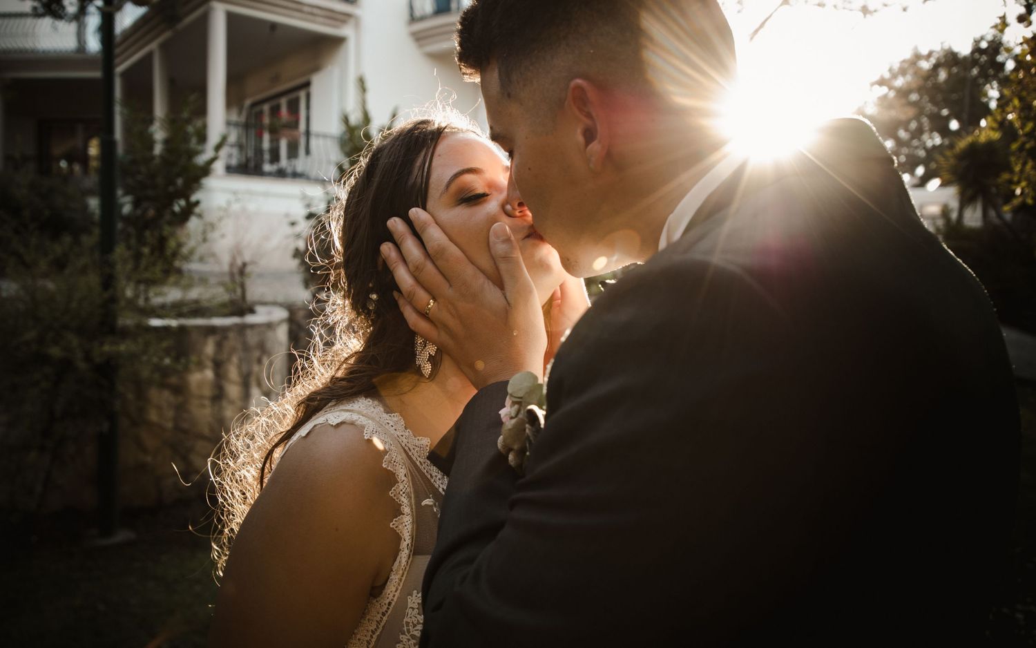 Romantic sunset moment between couple in wedding attire.