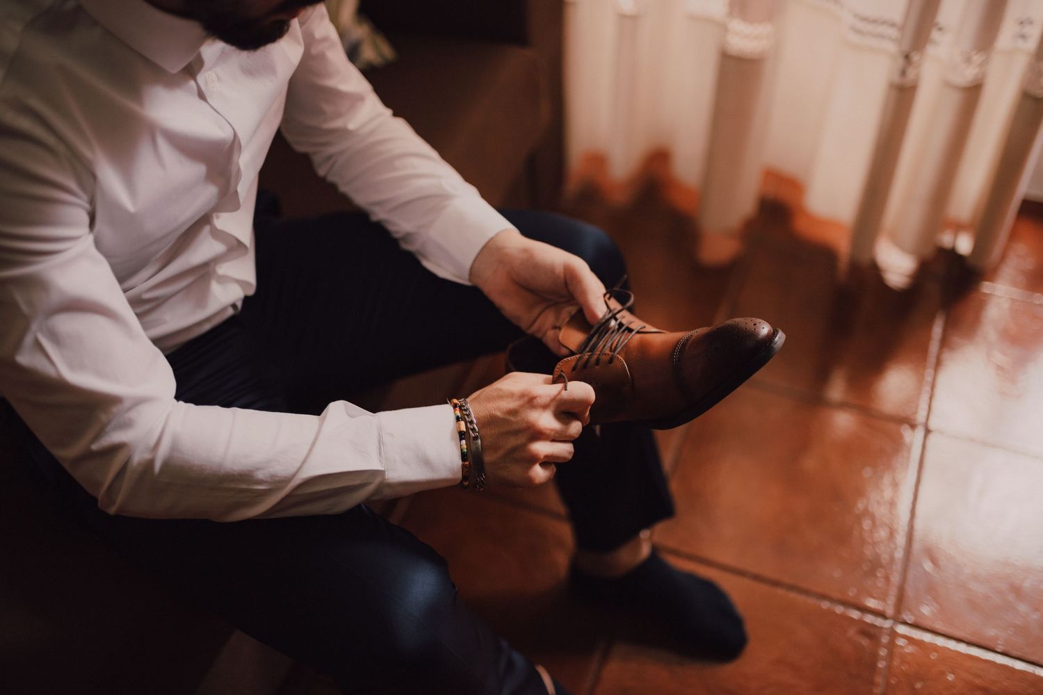 Close-up of dress shoes being polished during wedding preparations.