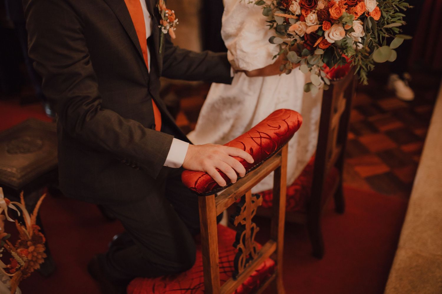 Close-up of hands holding a red book during a wedding ceremony.