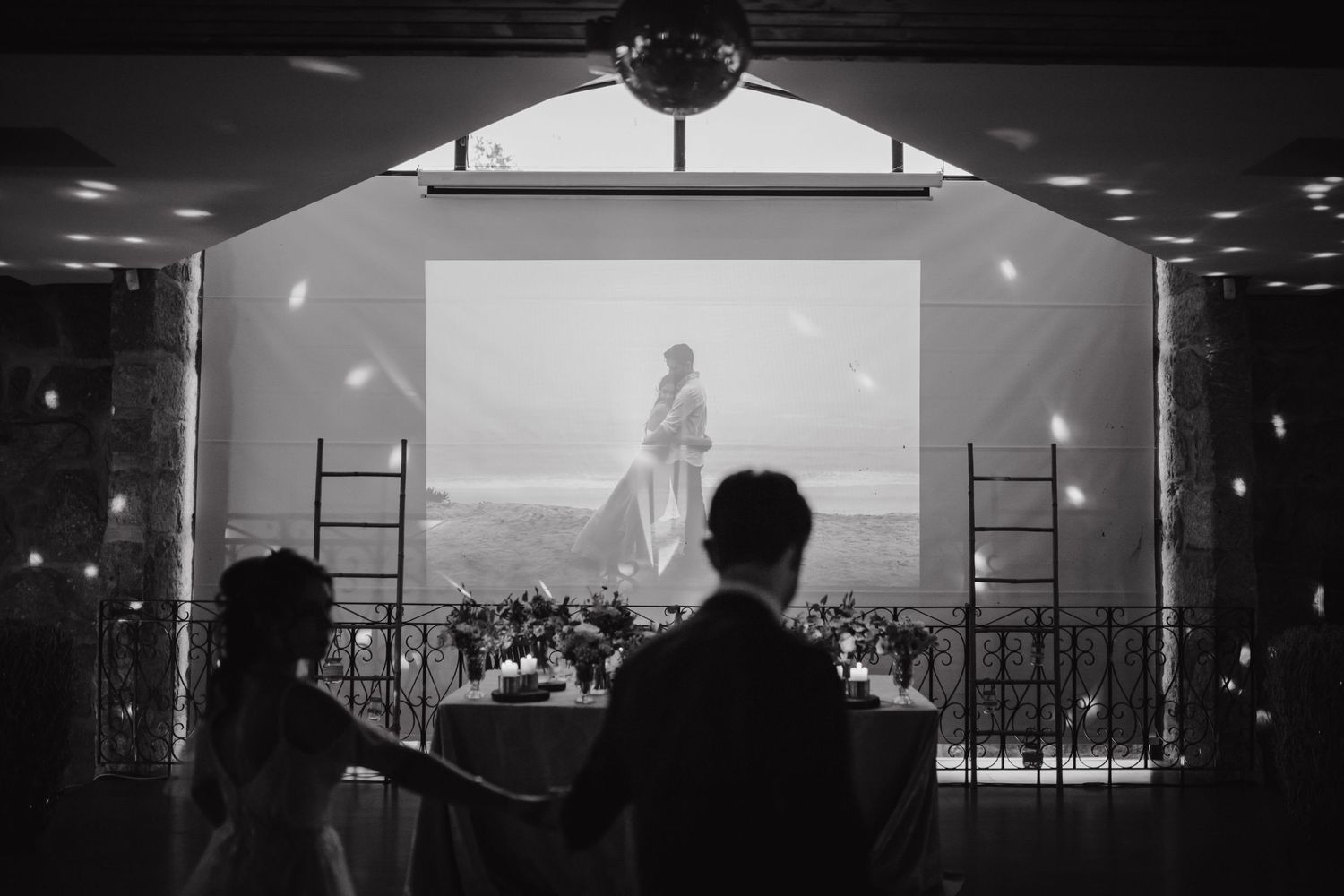 Black and white reception photo showing projection screen with silhouettes in foreground.