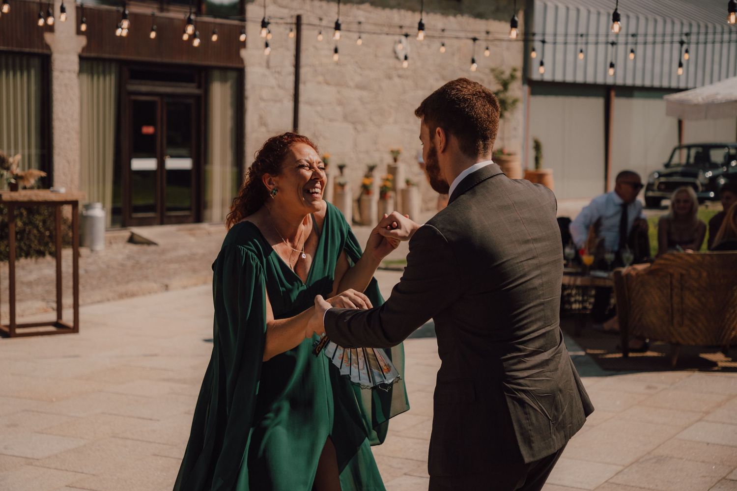 Guests dancing and laughing together at outdoor wedding reception.