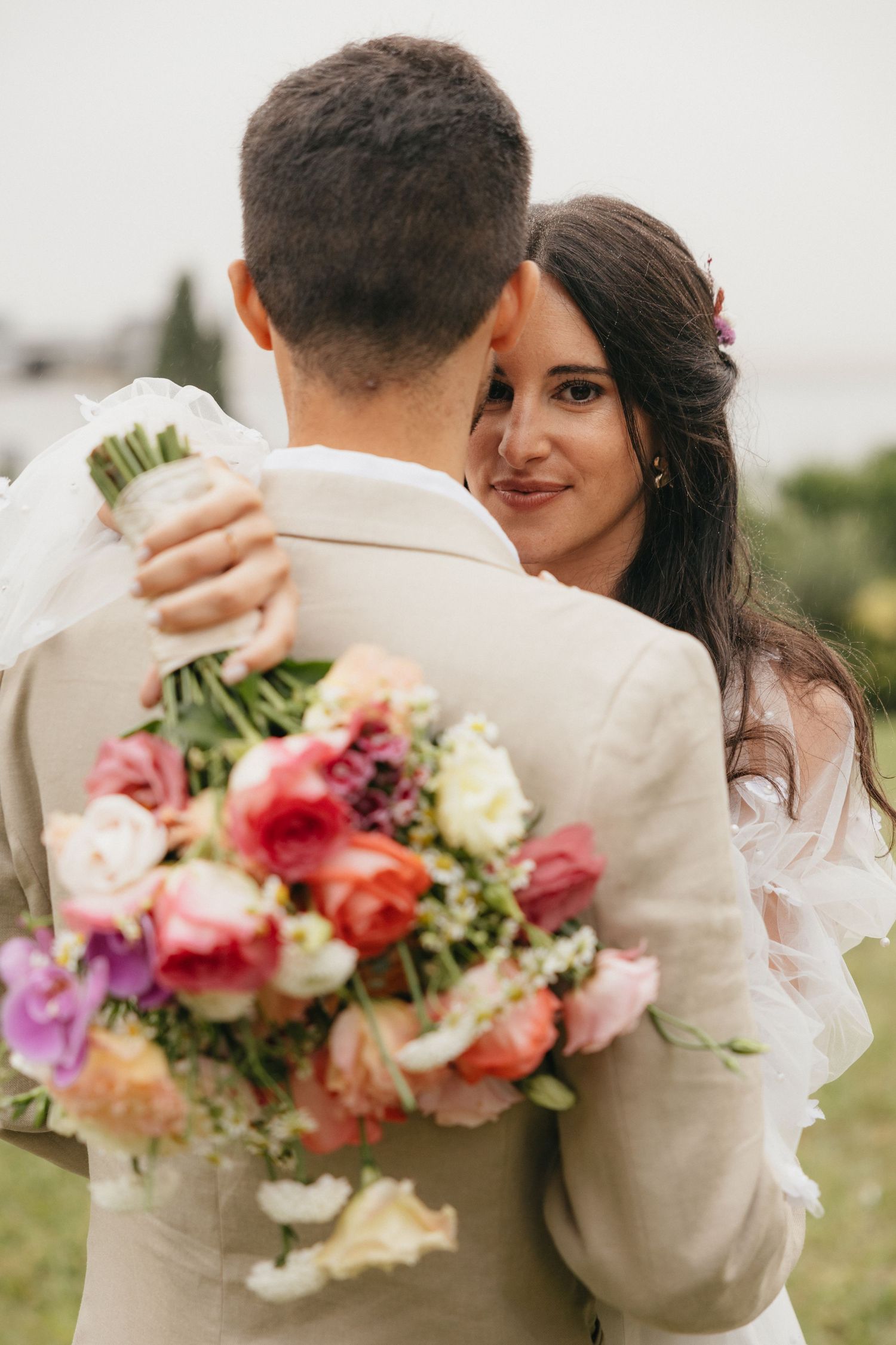 A romantic embrace with a colorful bouquet of flowers in the foreground.