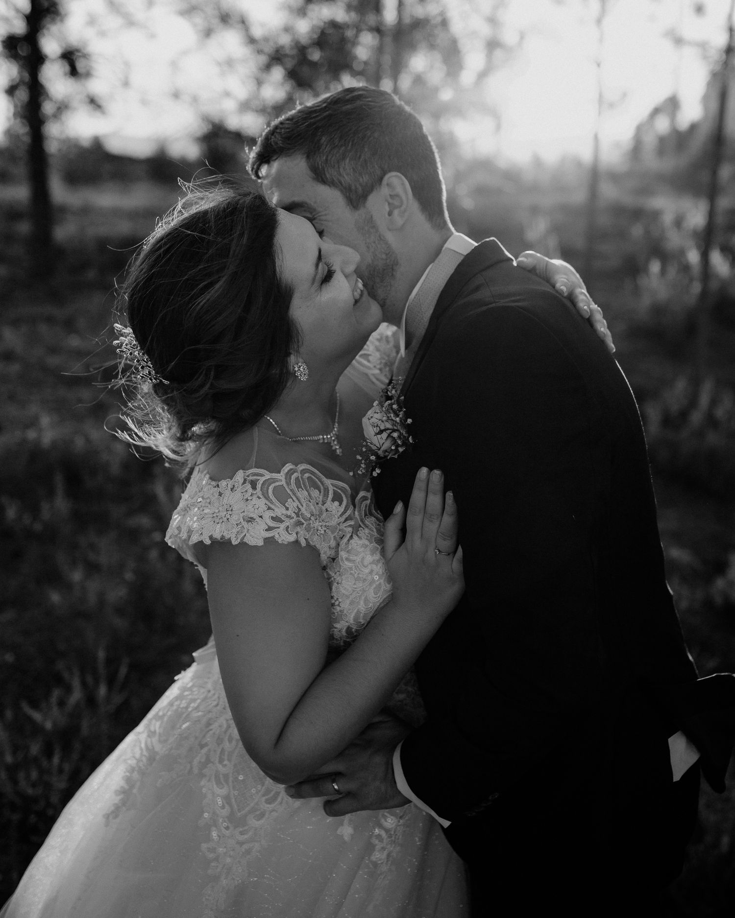 Black and white romantic portrait of a couple sharing an intimate moment in their wedding attire.