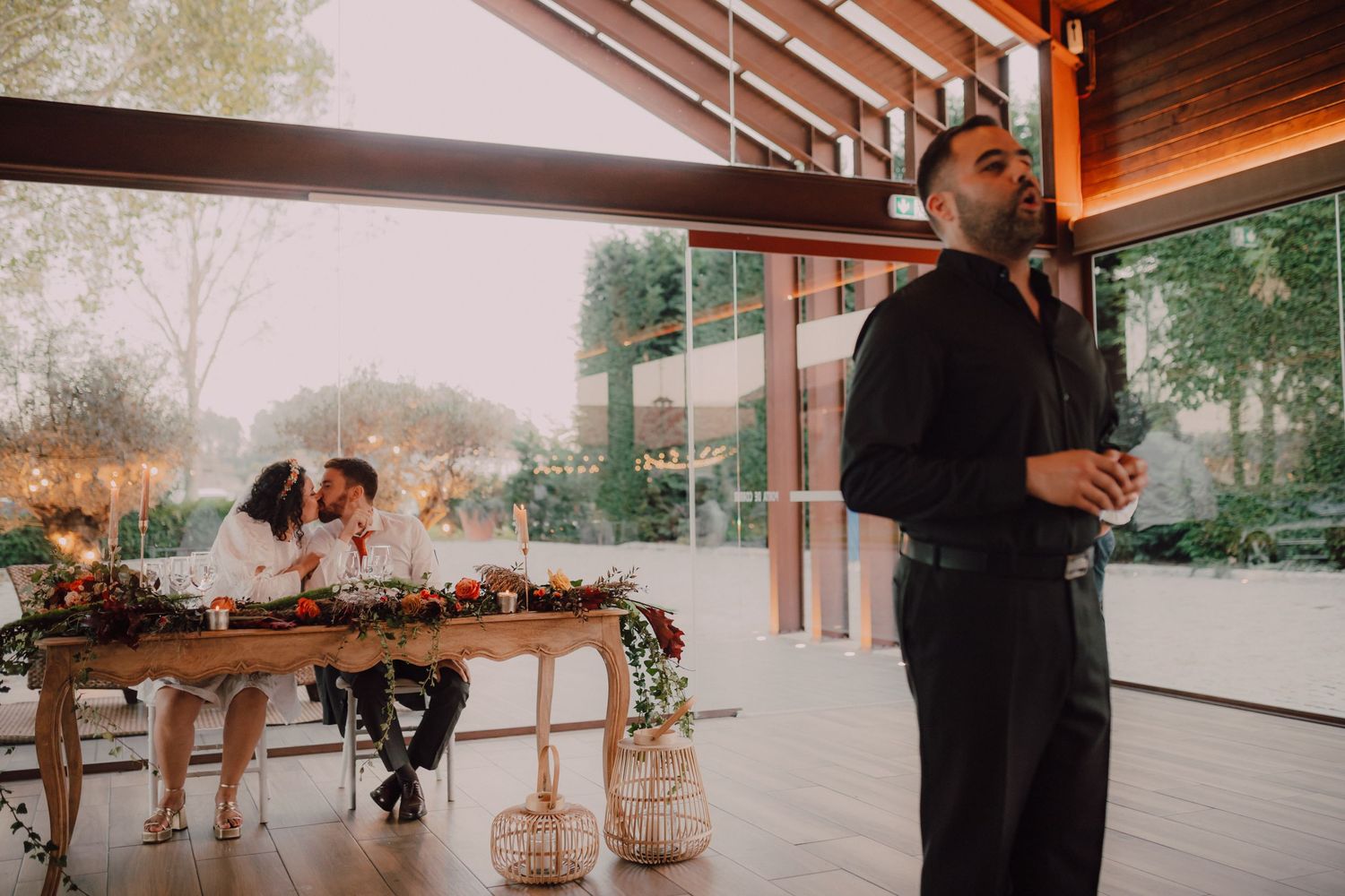 A server stands at attention while guests dine at a decorated table in the background.