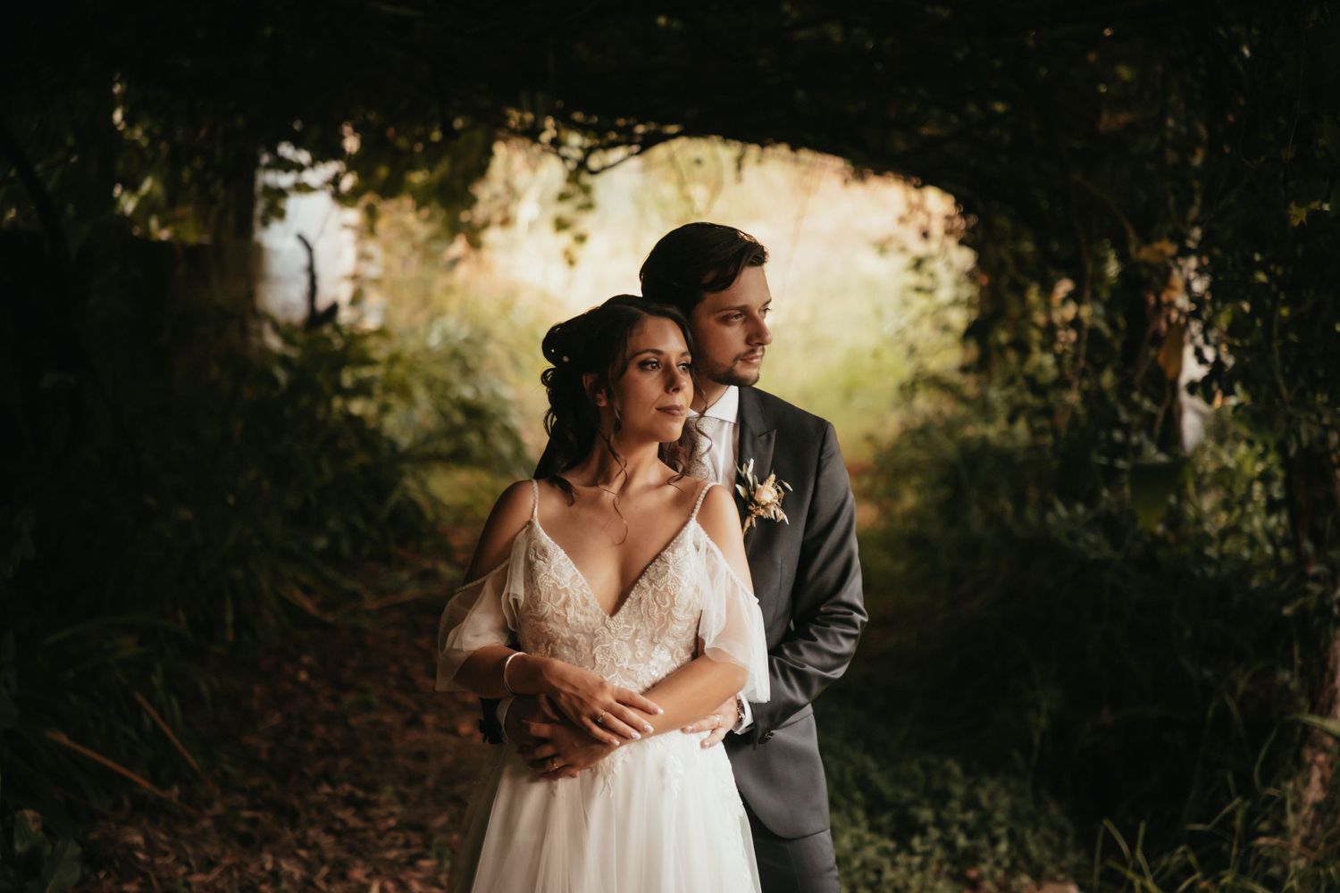 Romantic outdoor portrait in golden sunlight filtered through trees.