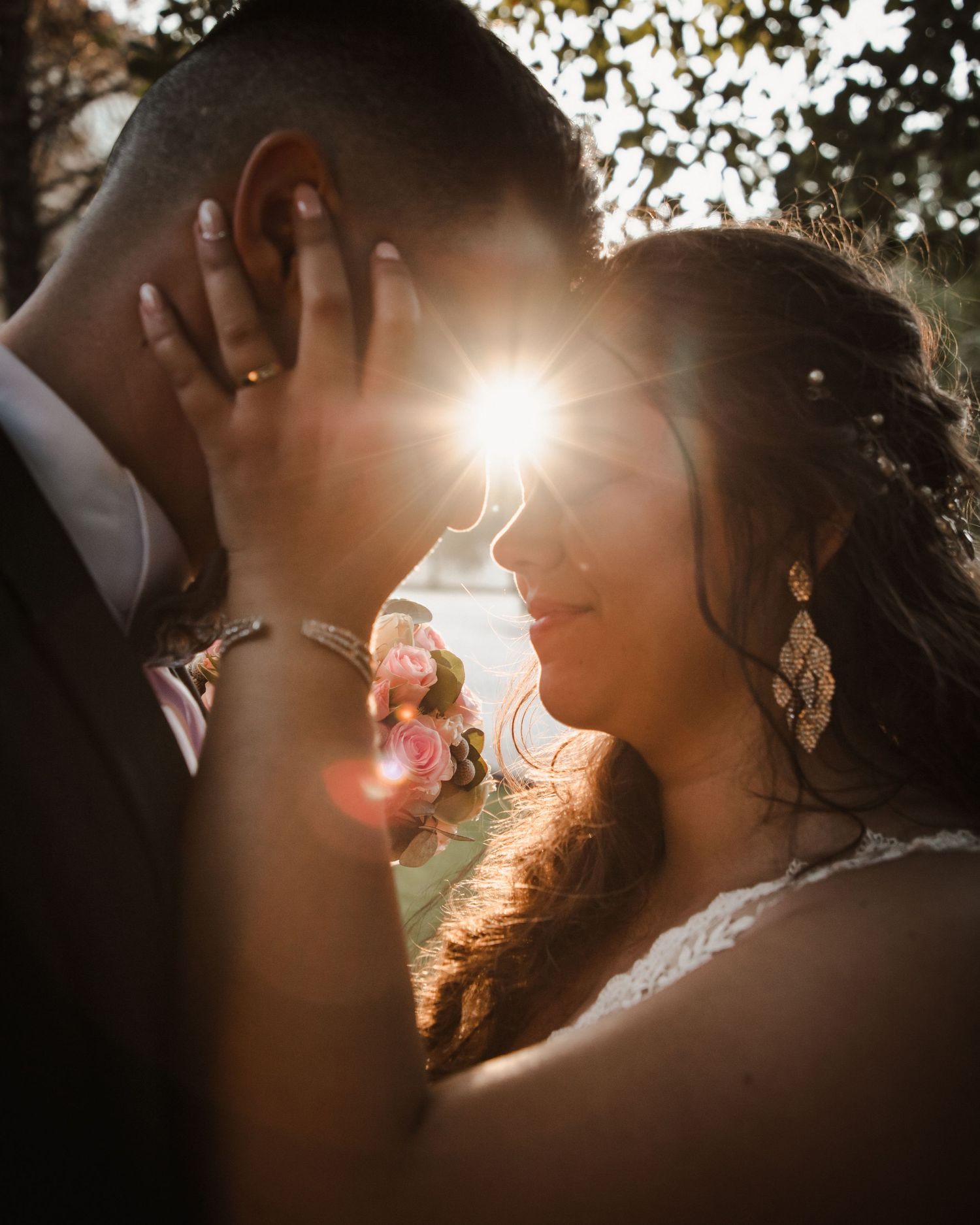 Golden sunset light illuminates a tender moment between newlyweds during their portrait session.