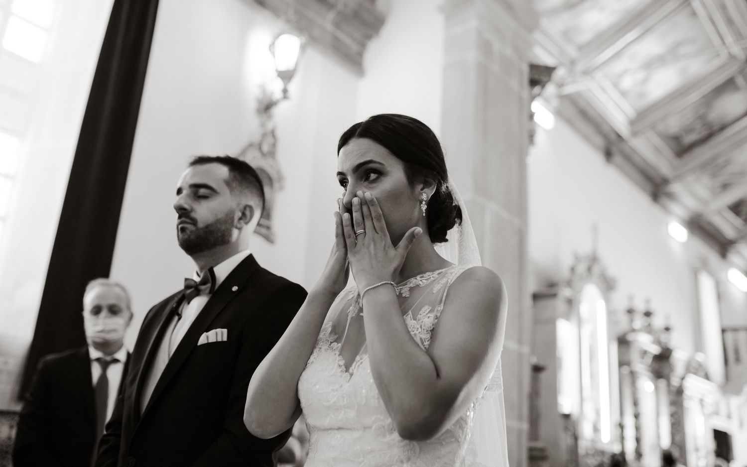 An emotional ceremony moment captured in black and white inside an ornate building.
