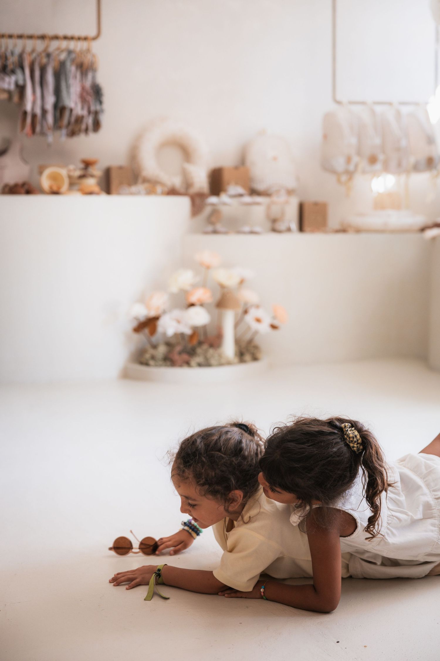 A sequence of photos showing someone lying on a white floor while observing a snail crawling in front of them.