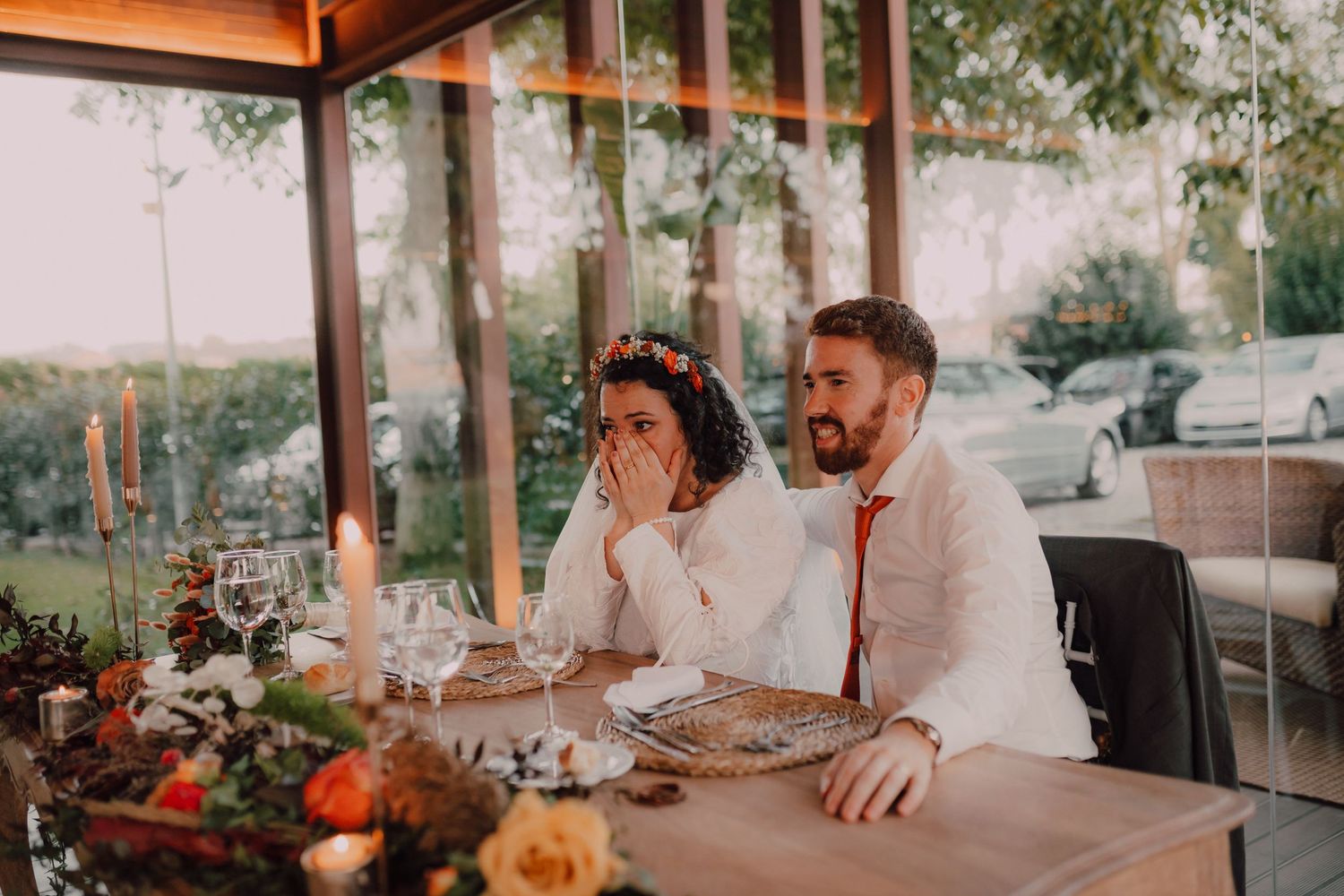 A couple shares an intimate moment at their reception dinner table decorated with floral centerpieces.