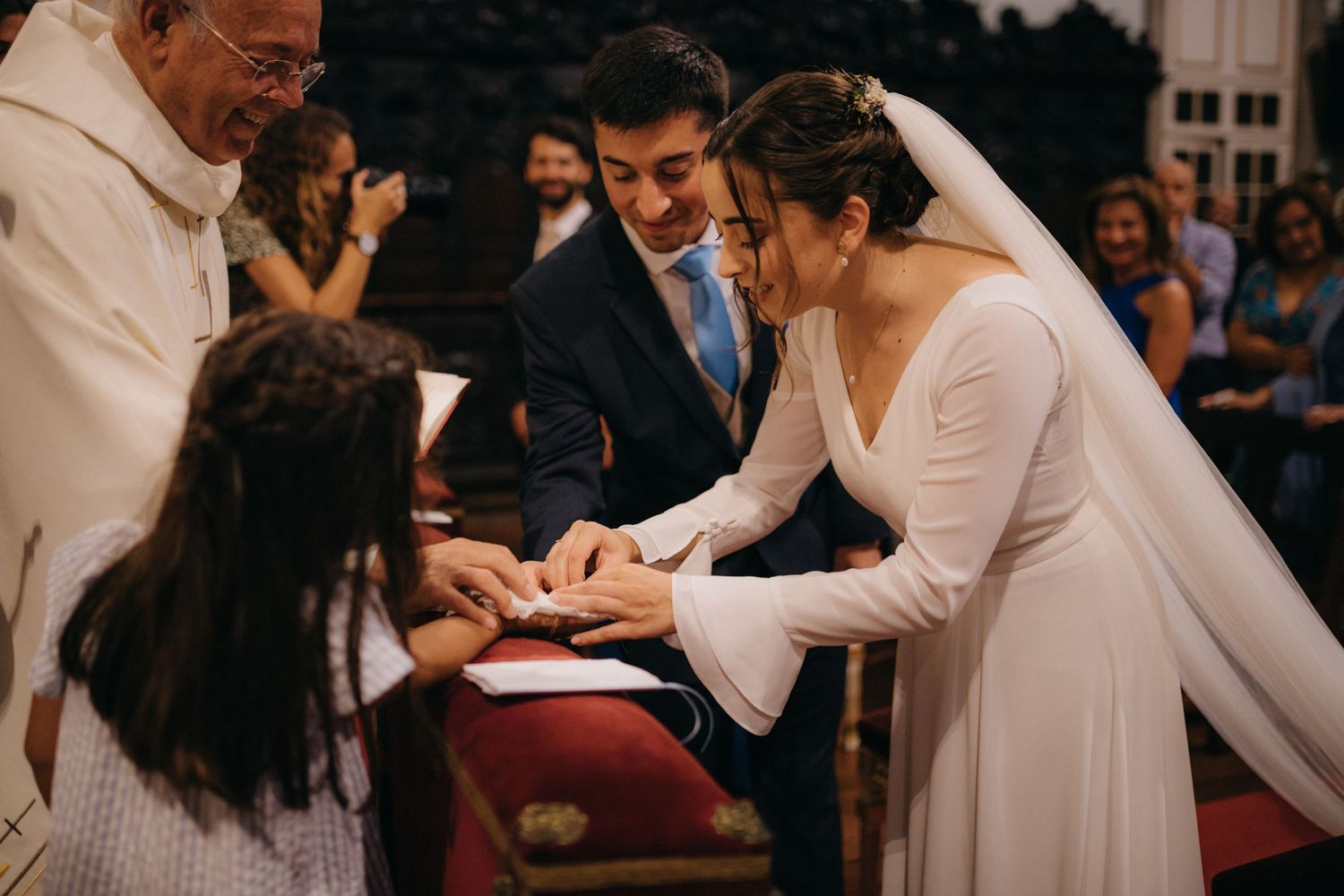 Wedding ceremony interaction between couple and guests in church setting.