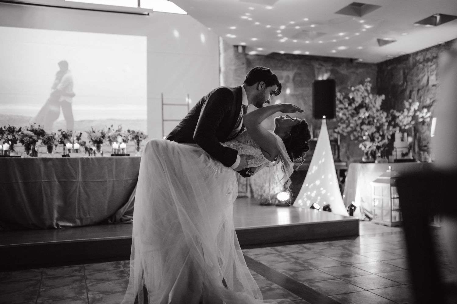 A dramatic black and white photo of a couple sharing a dance dip.