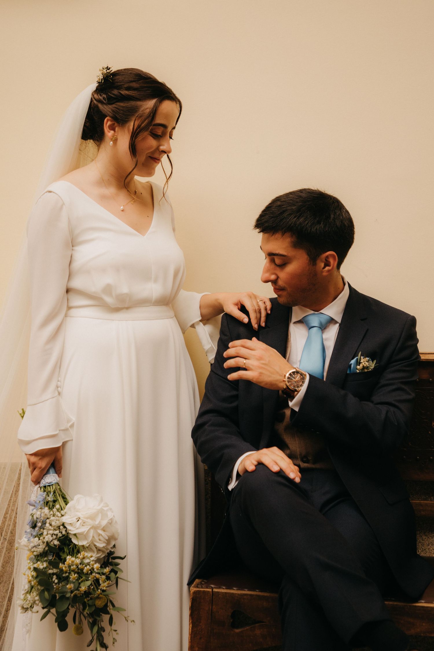 A wedding couple in elegant attire sharing an intimate moment during their ceremony.