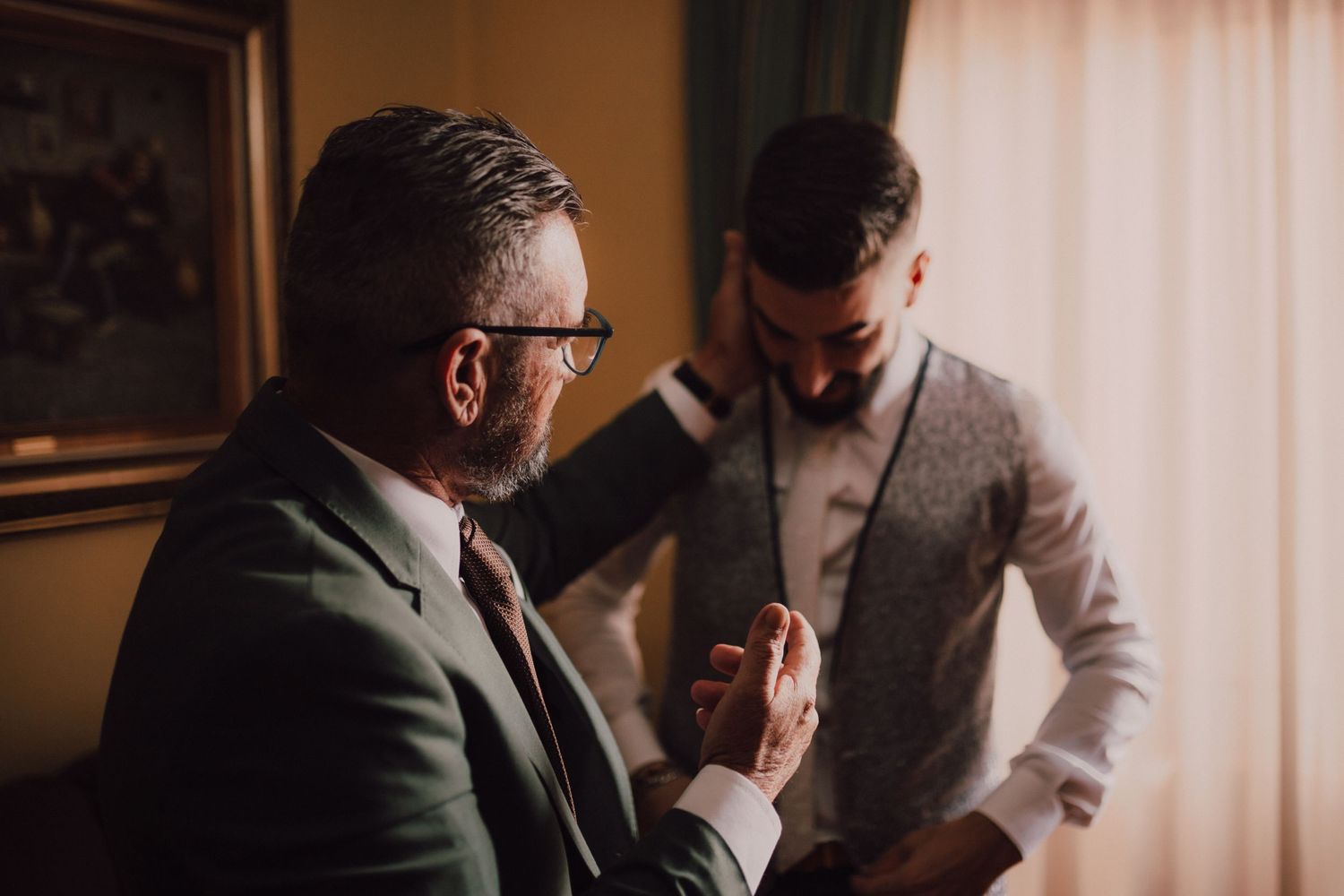 Wedding preparation scene in warm lighting with formal attire.