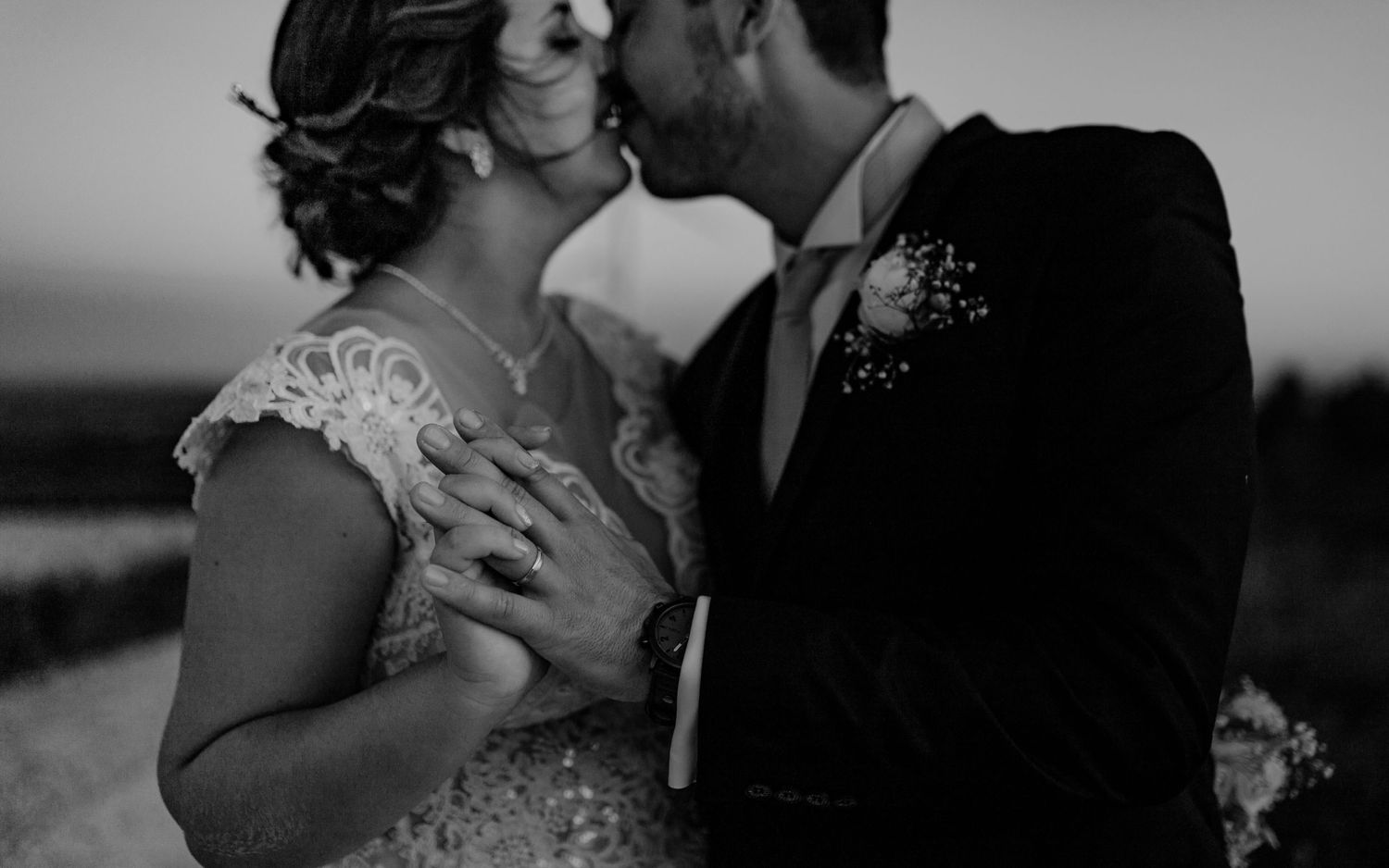 Intimate black and white portrait of couple sharing romantic moment in formalwear.