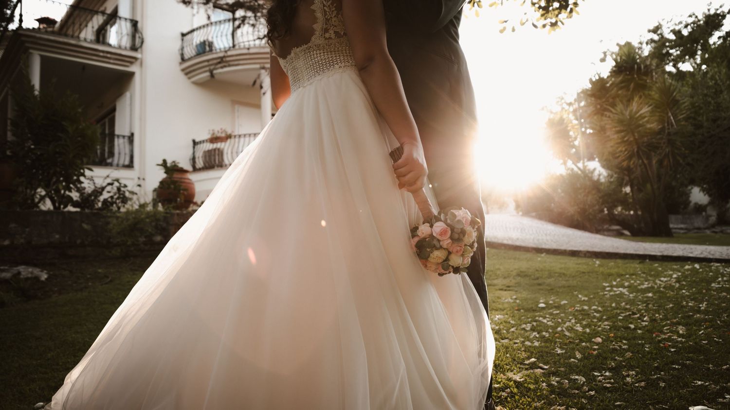 Sunlit silhouette of flowing wedding dress fabric during golden hour.