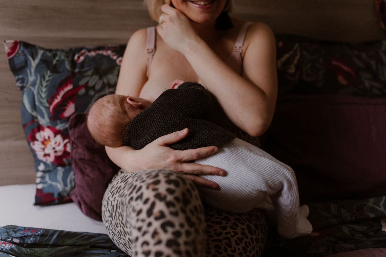 A sleeping Bengal cat curled up on a cozy blanket with spotted leopard print pattern.