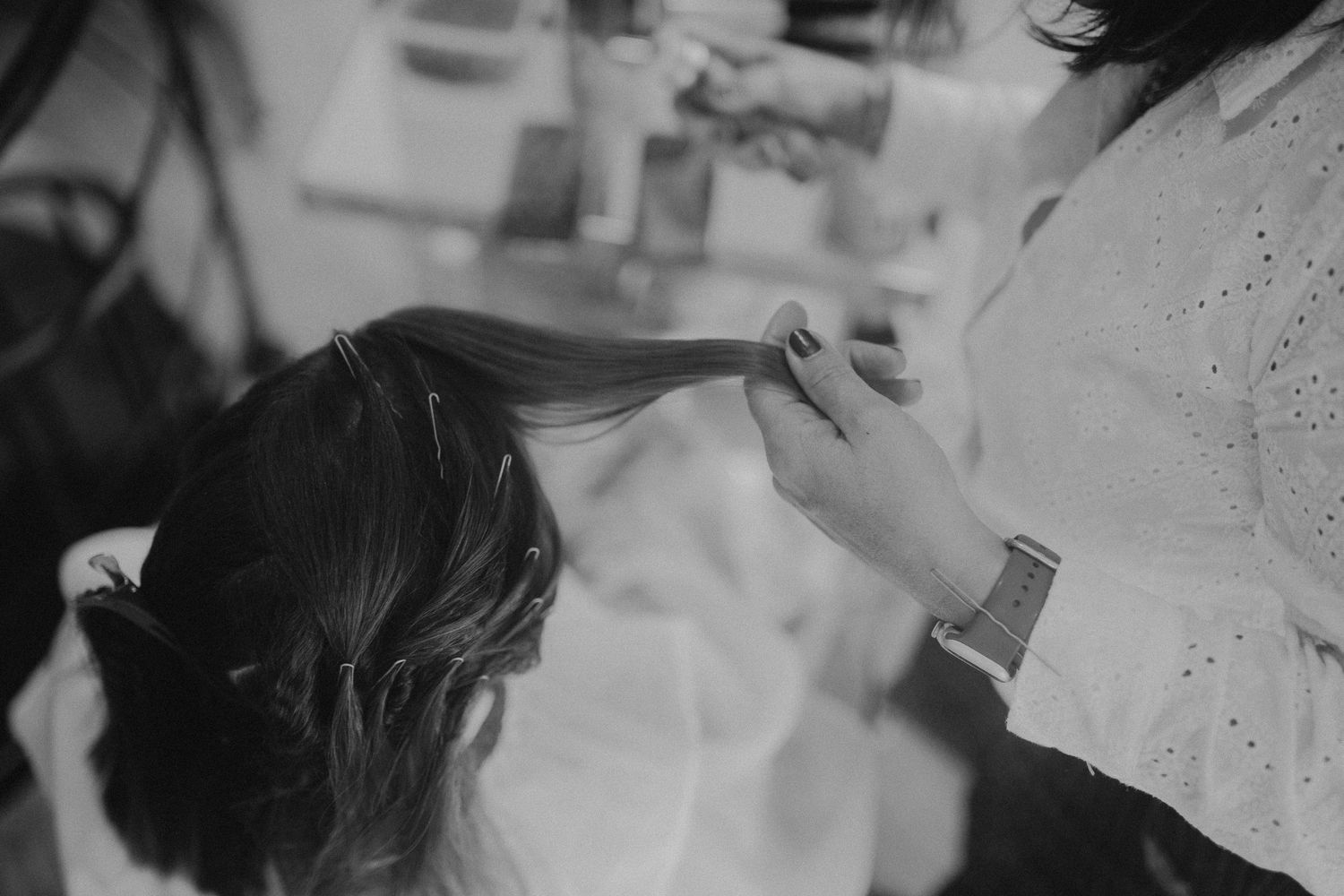 Black and white close up photo showing long dark hair being styled with a hair brush.