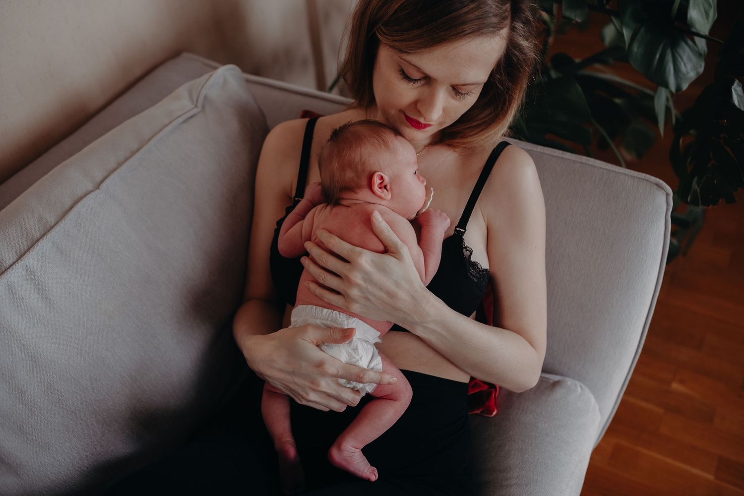 A series of intimate black and white photographs showing tender moments between parent and newborn baby.