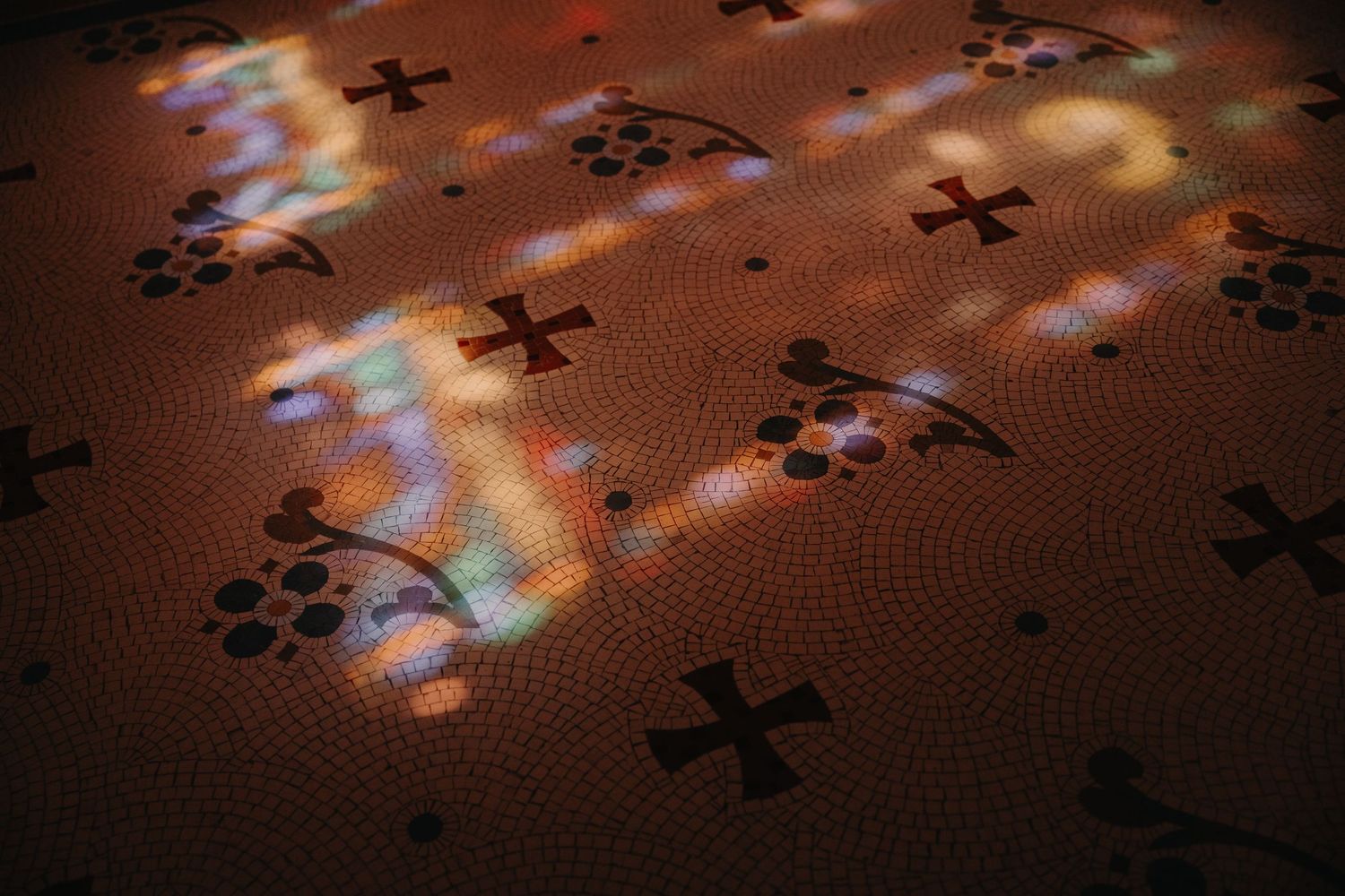Scattered black puzzle pieces on a textured brown surface with light reflections creating a dynamic pattern.